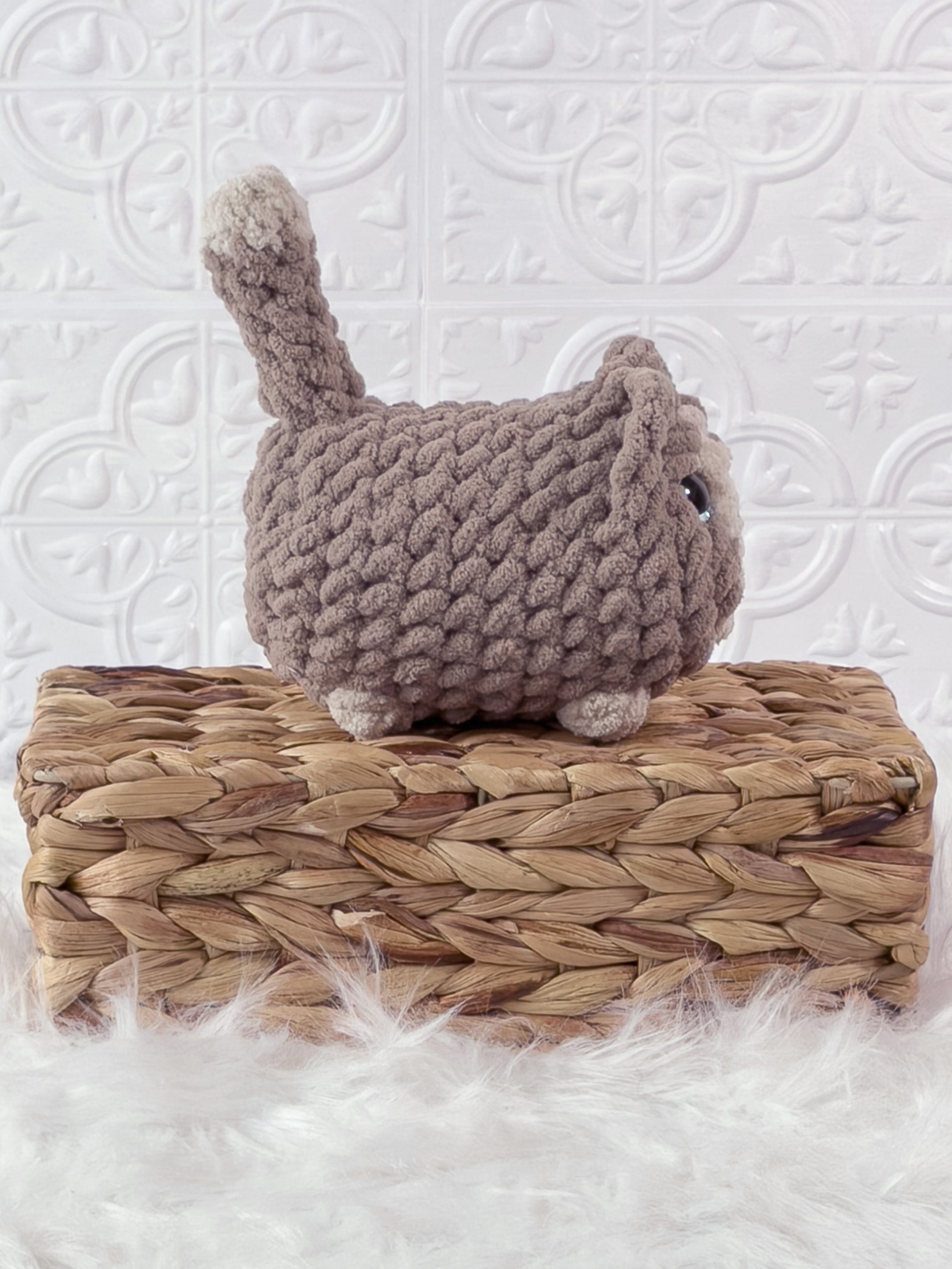 Handmade beige loaf cat crochet plushie shown from the side