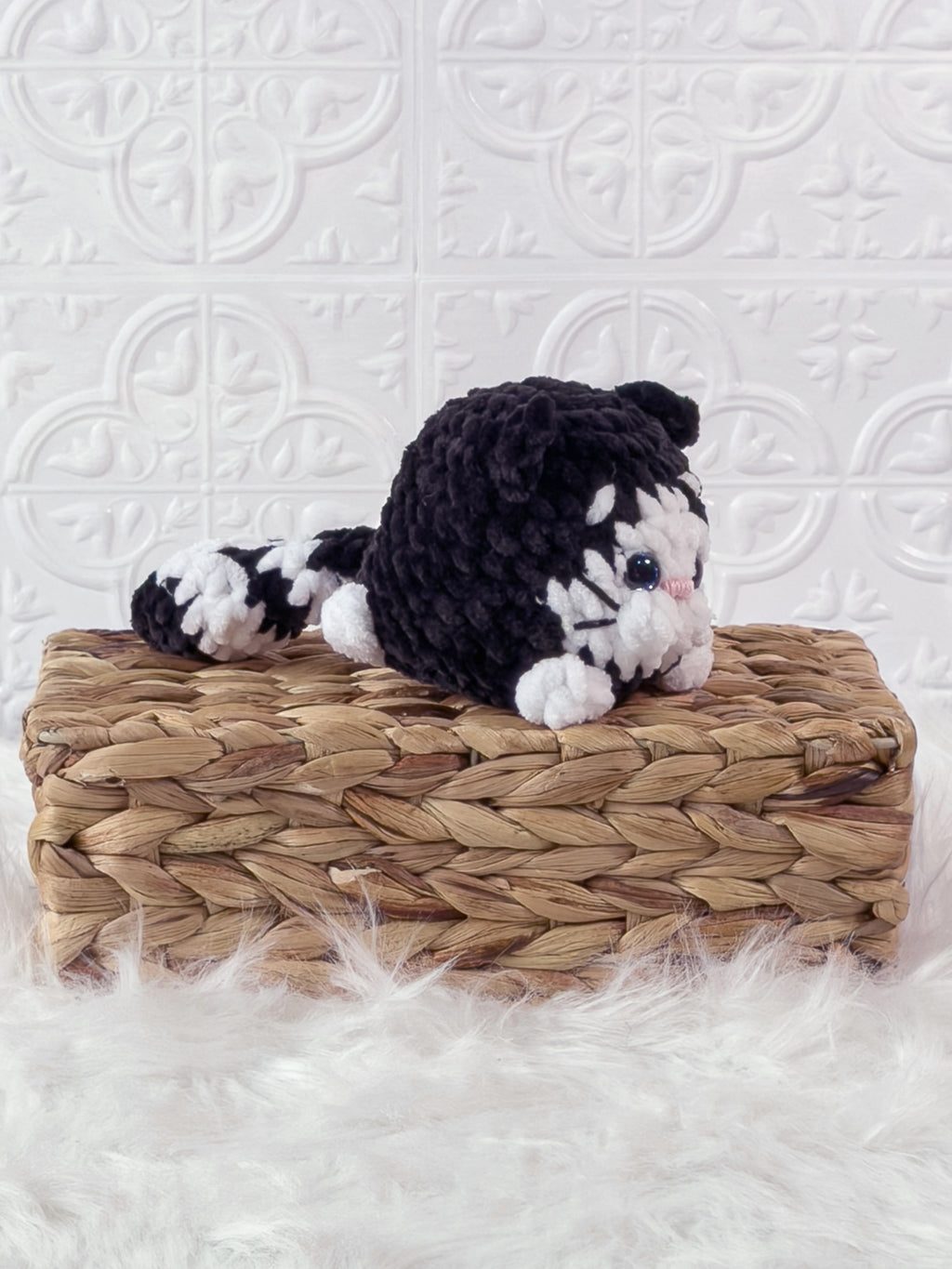 Handmade black kitten crochet plushie shown from an angled view