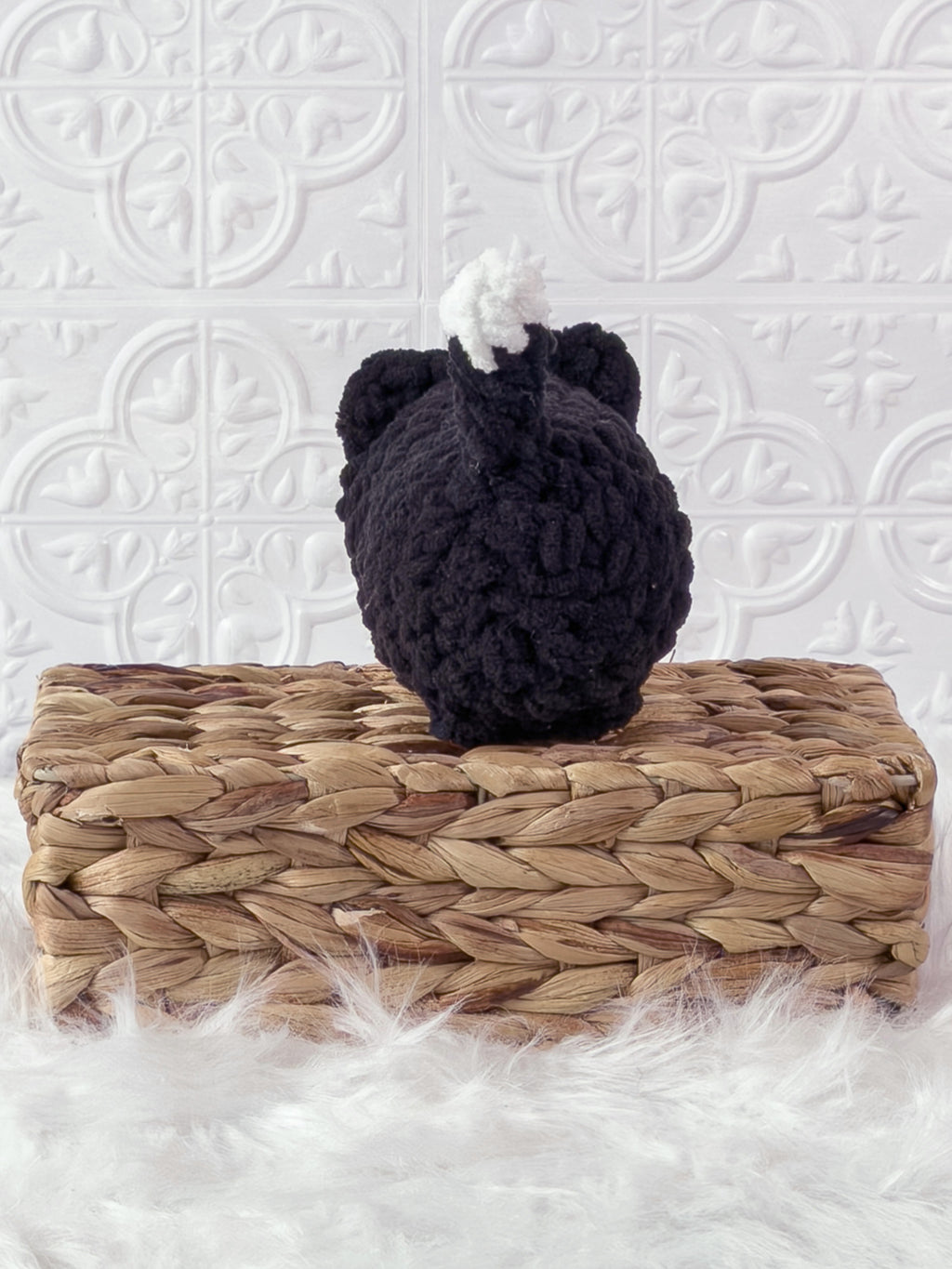 Handmade black loaf cat crochet plushie shown from the back