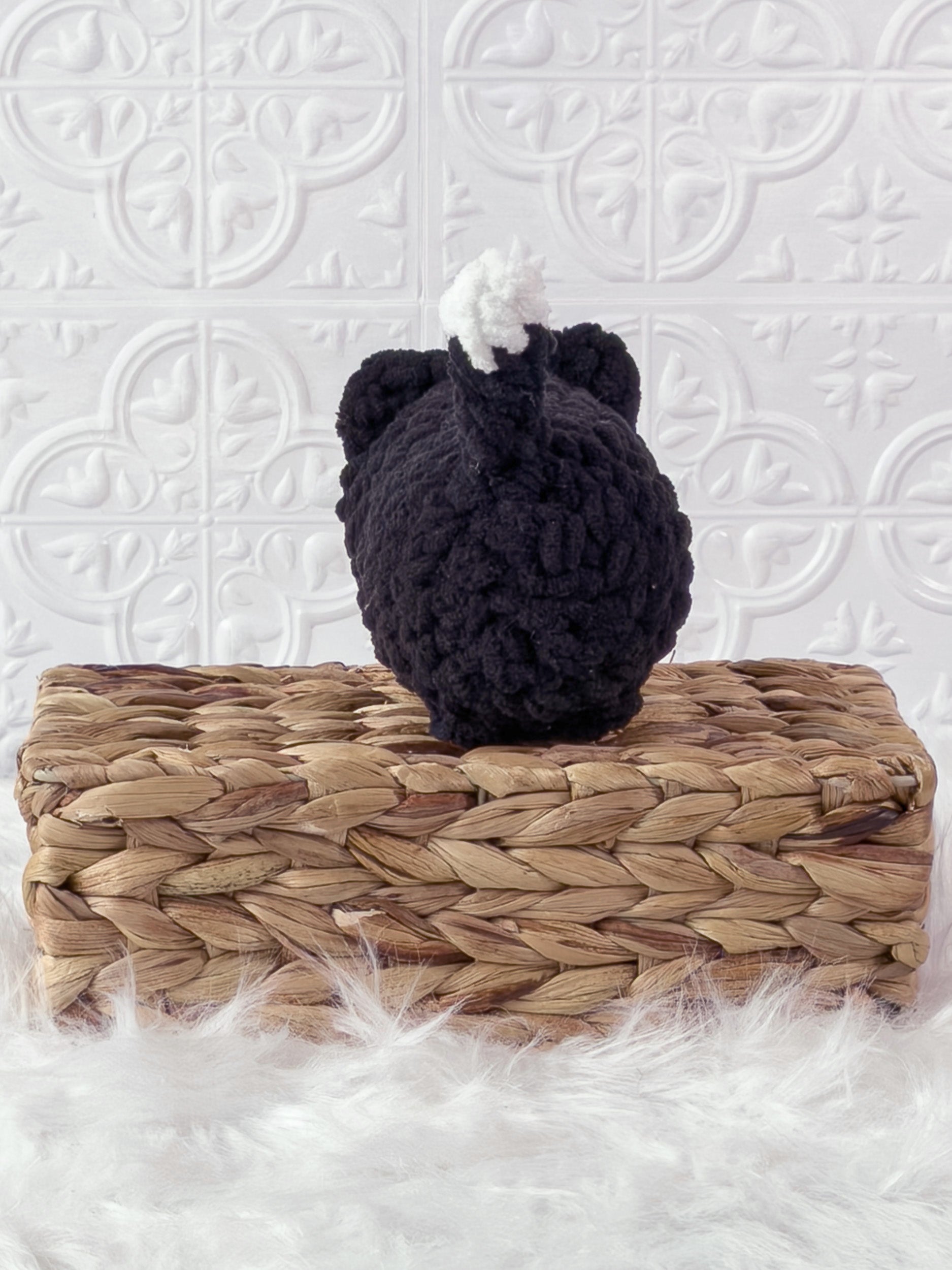 Handmade black loaf cat crochet plushie shown from the back