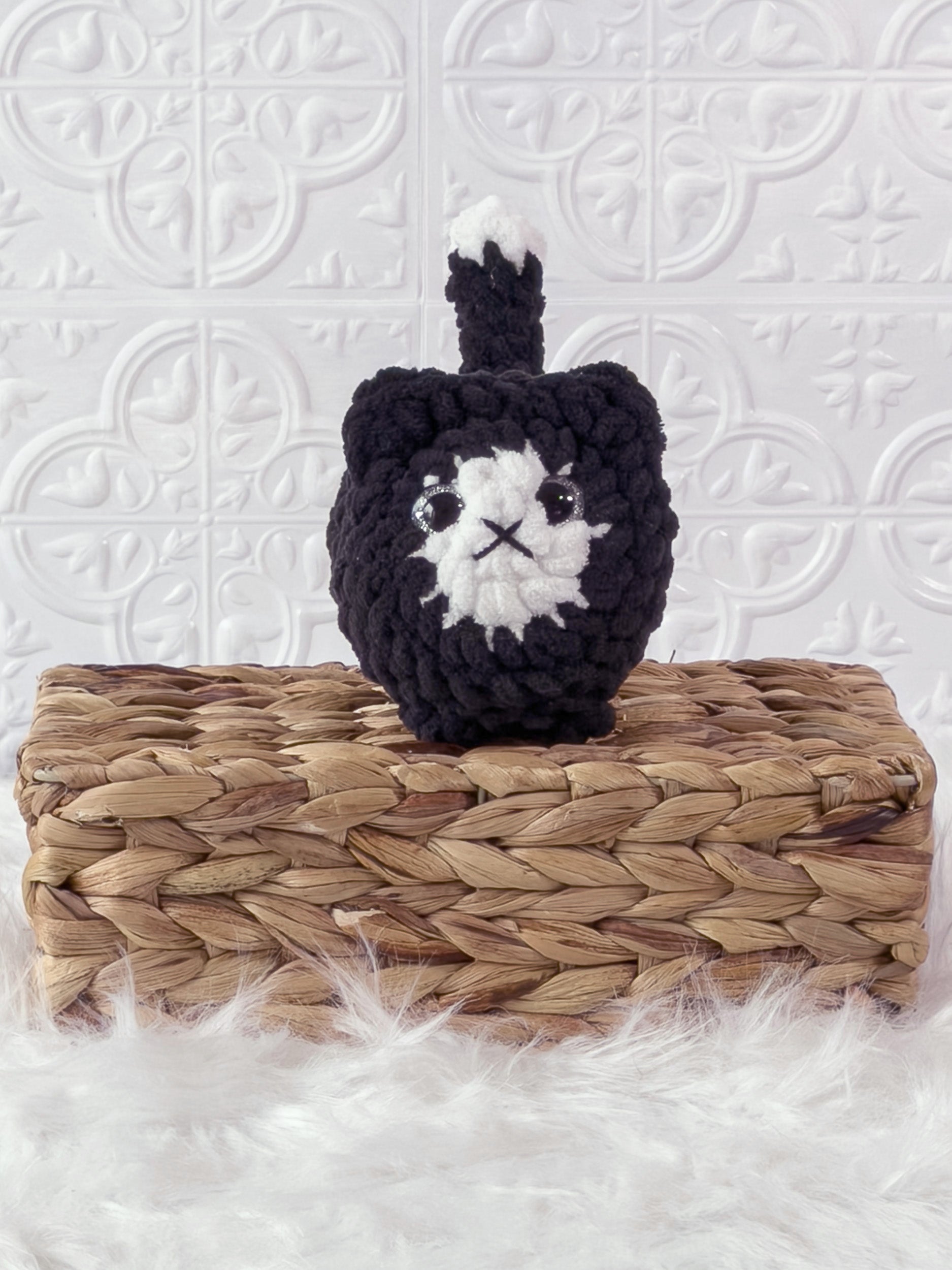 Handmade black loaf cat crochet plushie shown from the front