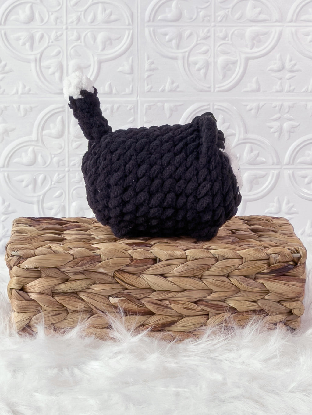 Handmade black loaf cat crochet plushie shown from the side
