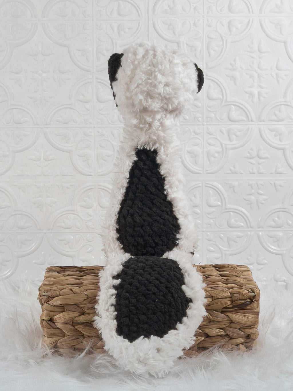 Handmade black skunk crochet plushie shown from the back