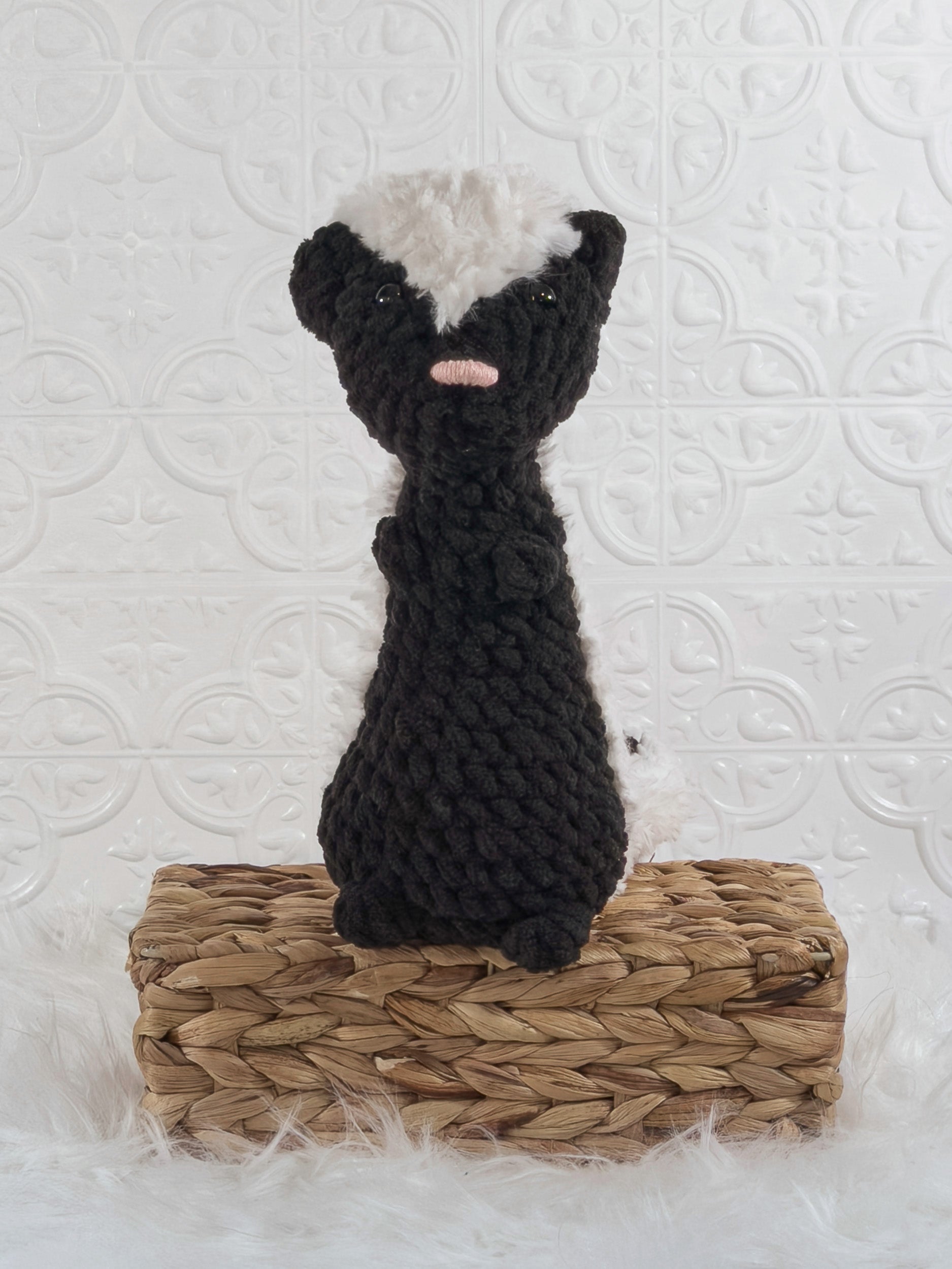 Handmade black skunk crochet plushie shown from the front