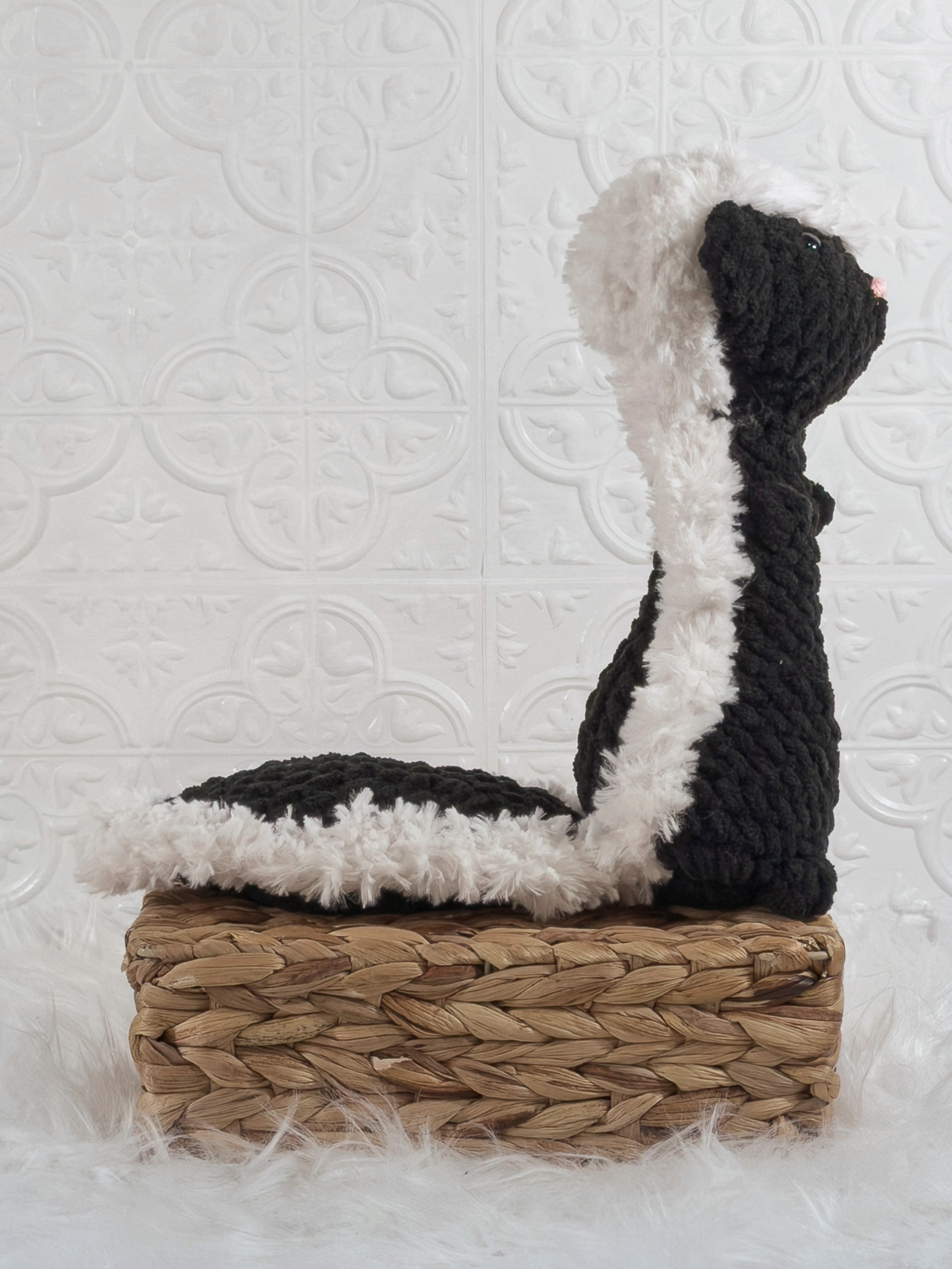 Handmade black skunk crochet plushie shown from the back