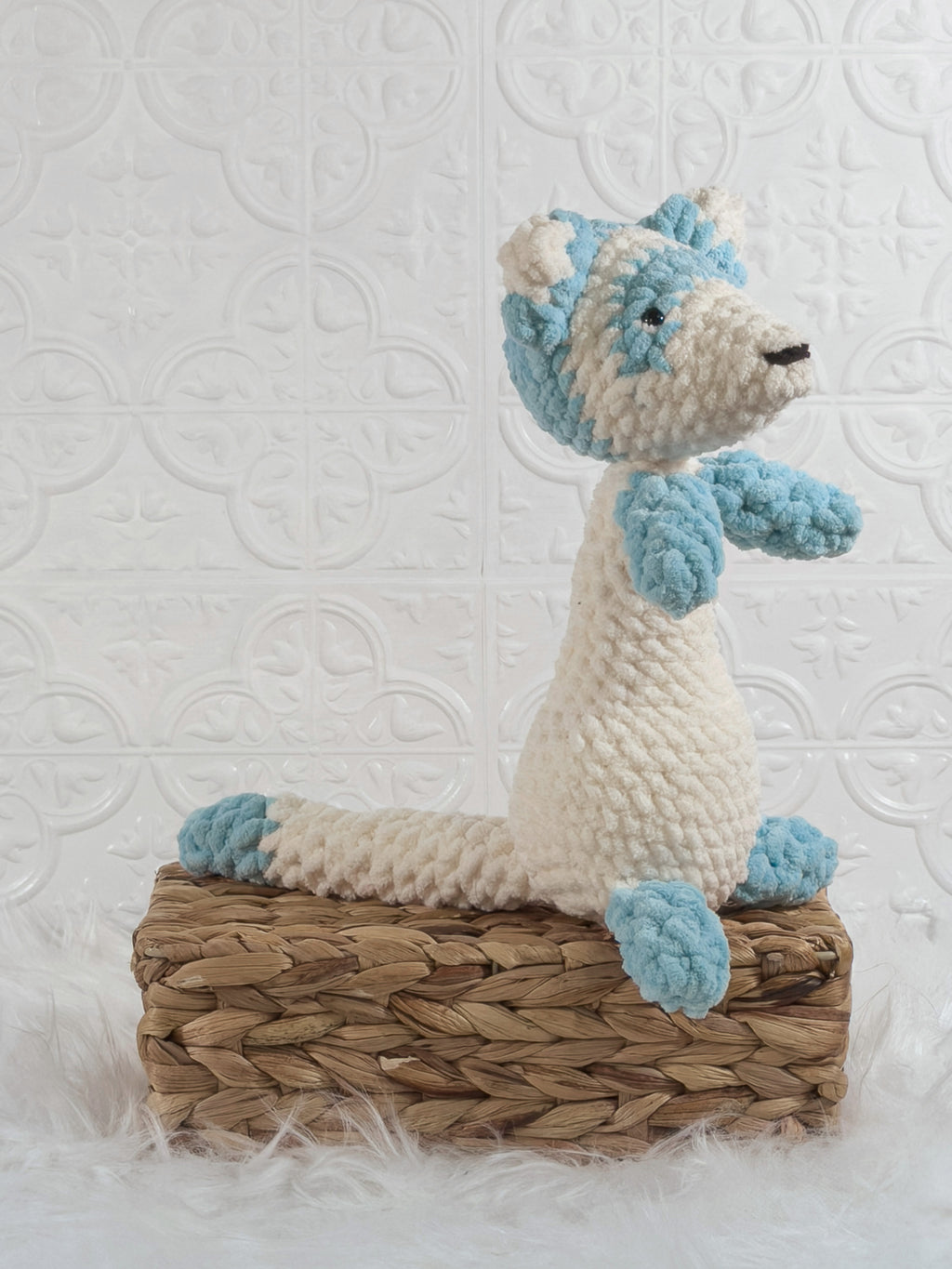 Handmade blue ferret crochet plushie shown from an angled view