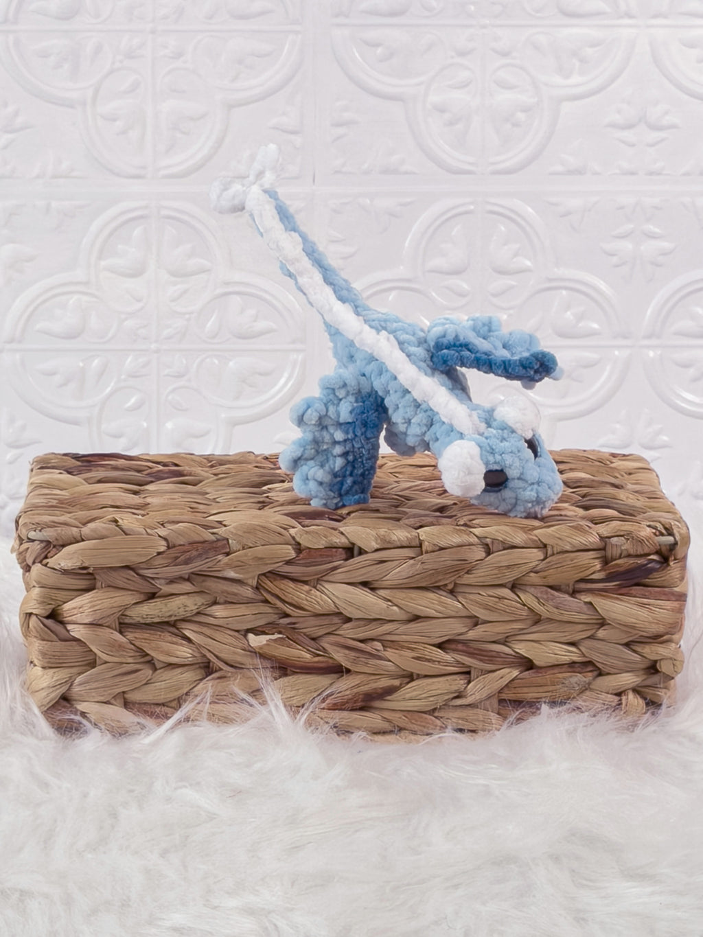 Handmade blue mini dragon crochet plushie shown from an angled view