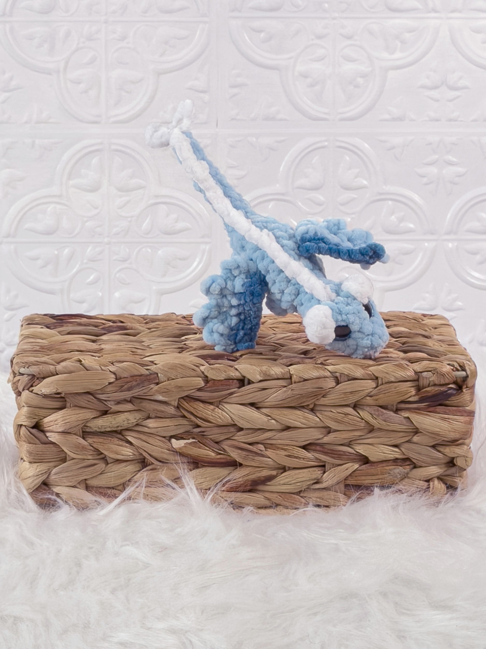 Handmade blue mini dragon crochet plushie shown from an angled view