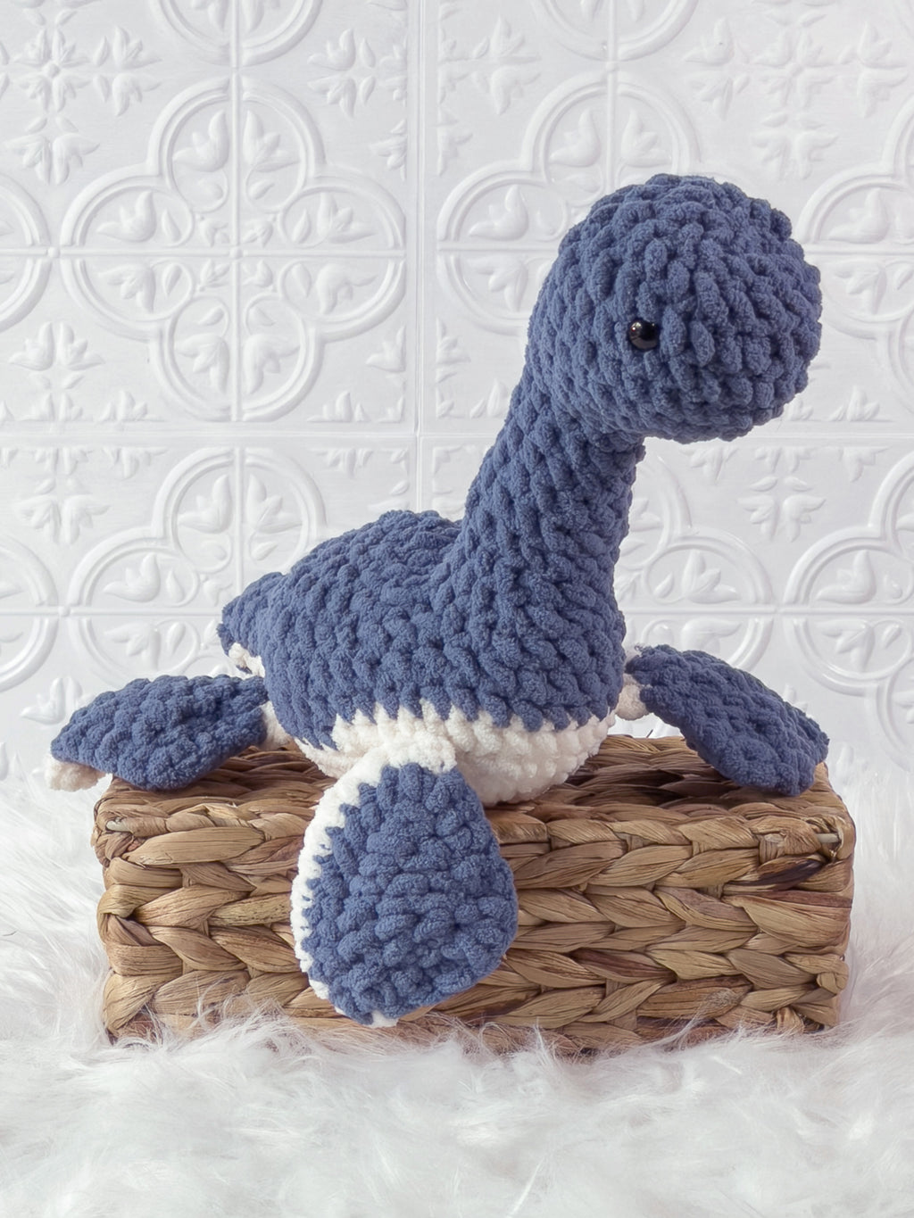 Handmade blue plesiosaurus crochet plushie shown from an angled view
