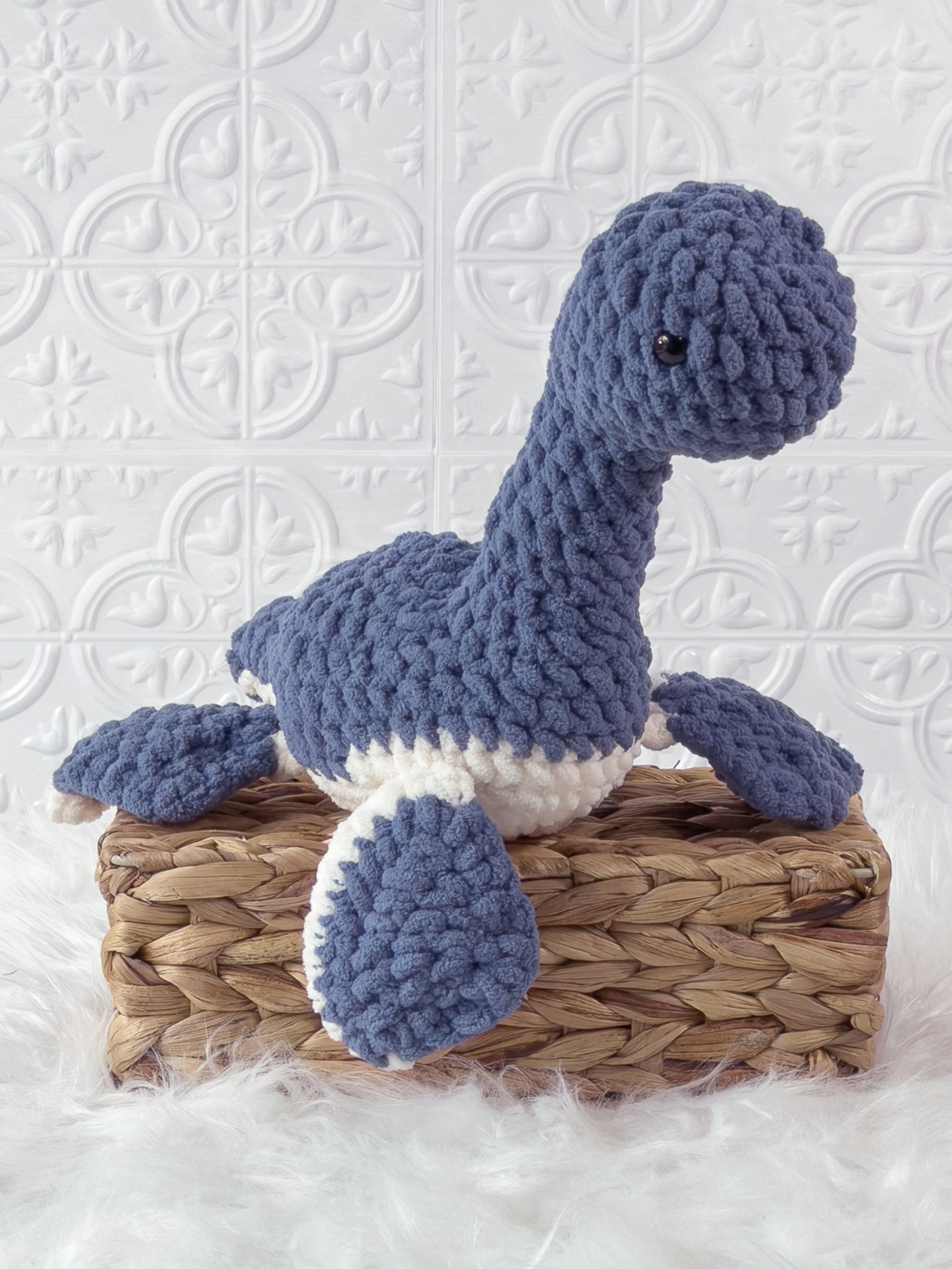 Handmade blue plesiosaurus crochet plushie shown from an angled view