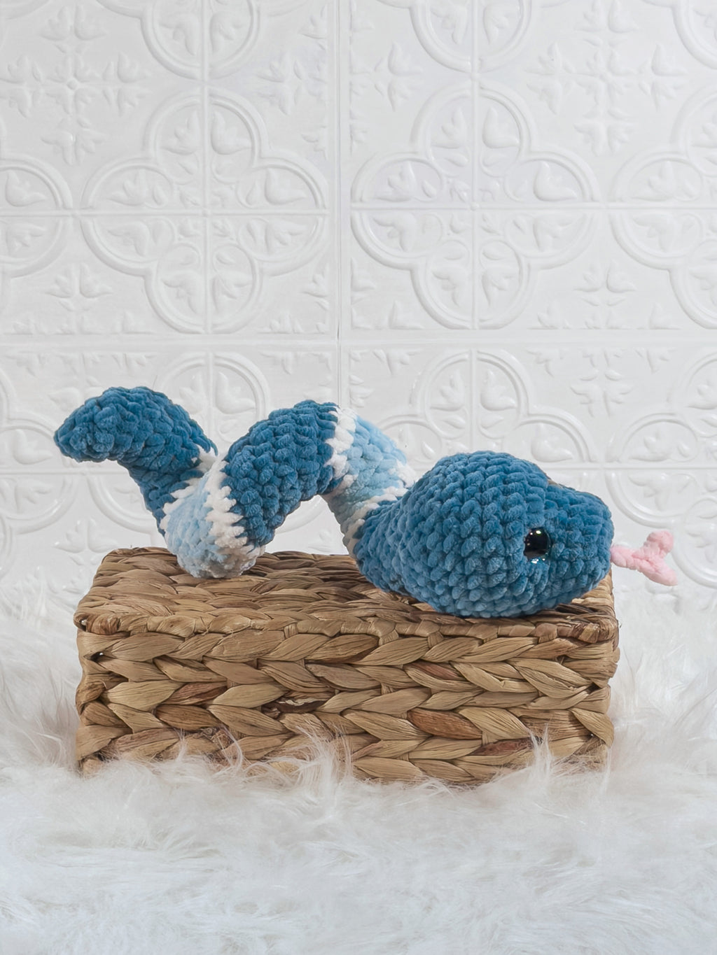 Handmade blue snake crochet plushie shown from an angled view