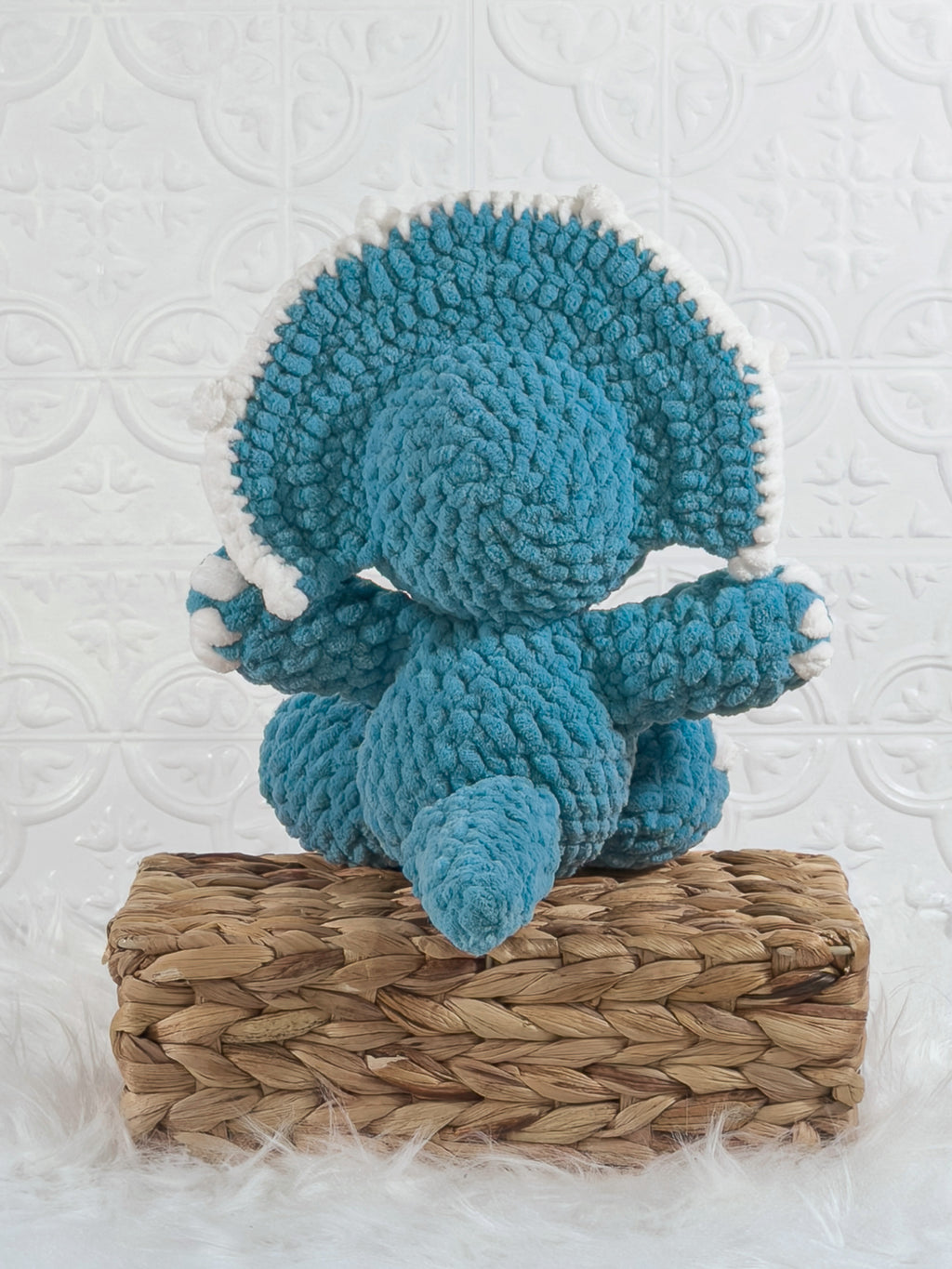 Handmade blue triceratops crochet plushie shown from the back