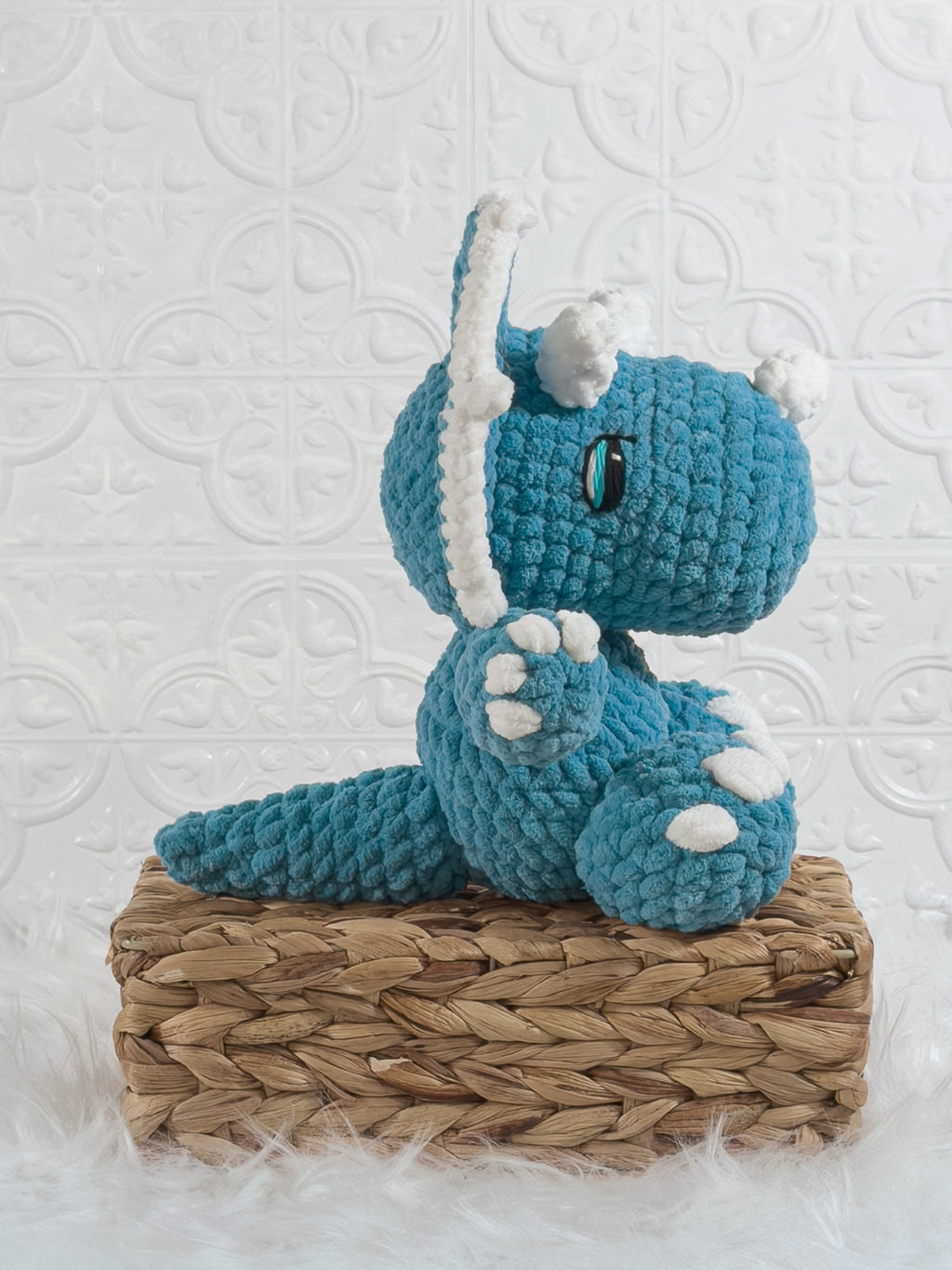 Handmade blue triceratops crochet plushie shown from the side