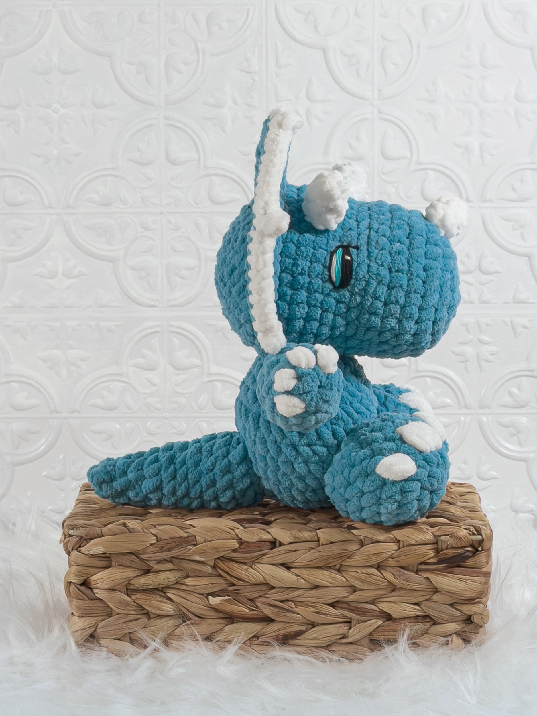 Handmade blue triceratops crochet plushie shown from the side