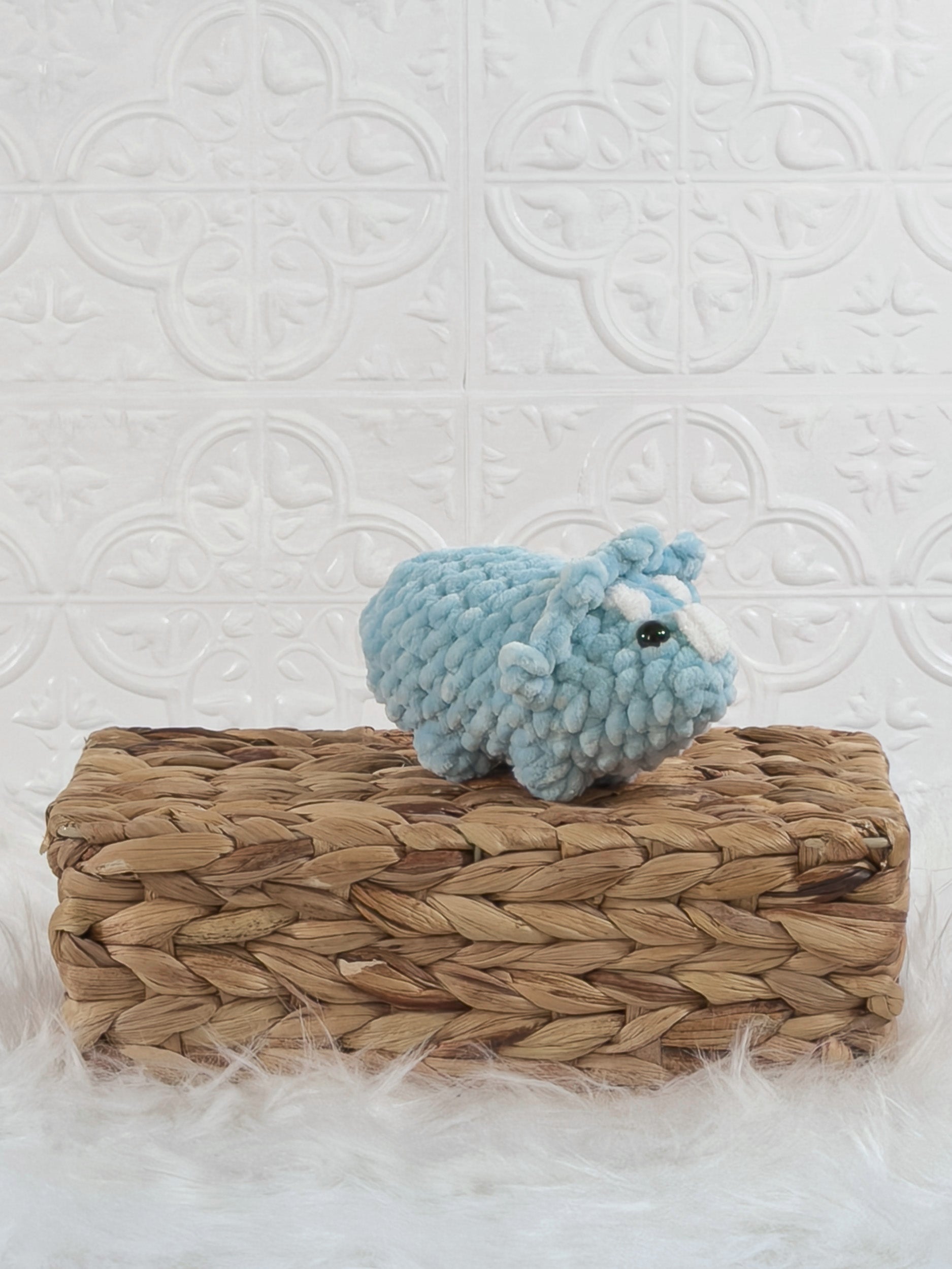 Handmade blue triceratops crochet plushie shown from an angled view