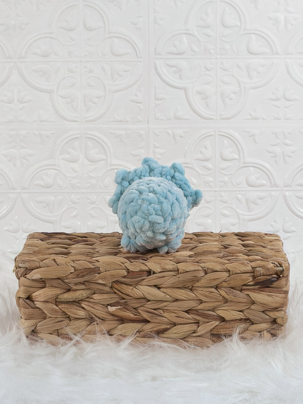 Handmade blue triceratops crochet plushie shown from the back