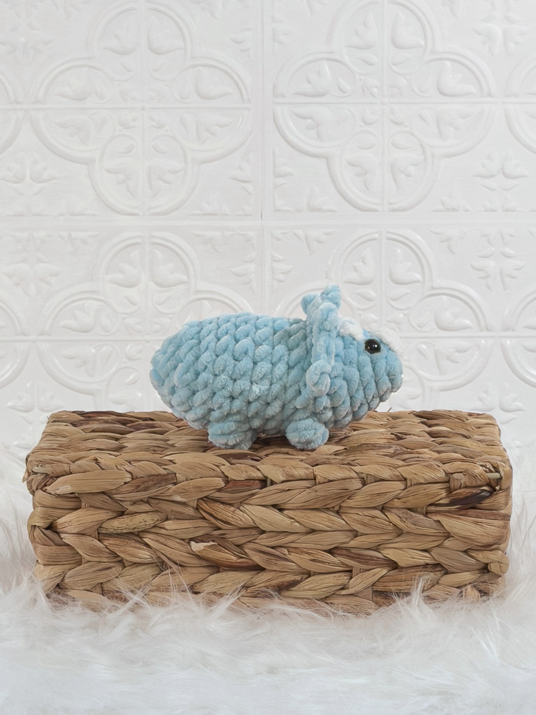 Handmade blue triceratops crochet plushie shown from the side