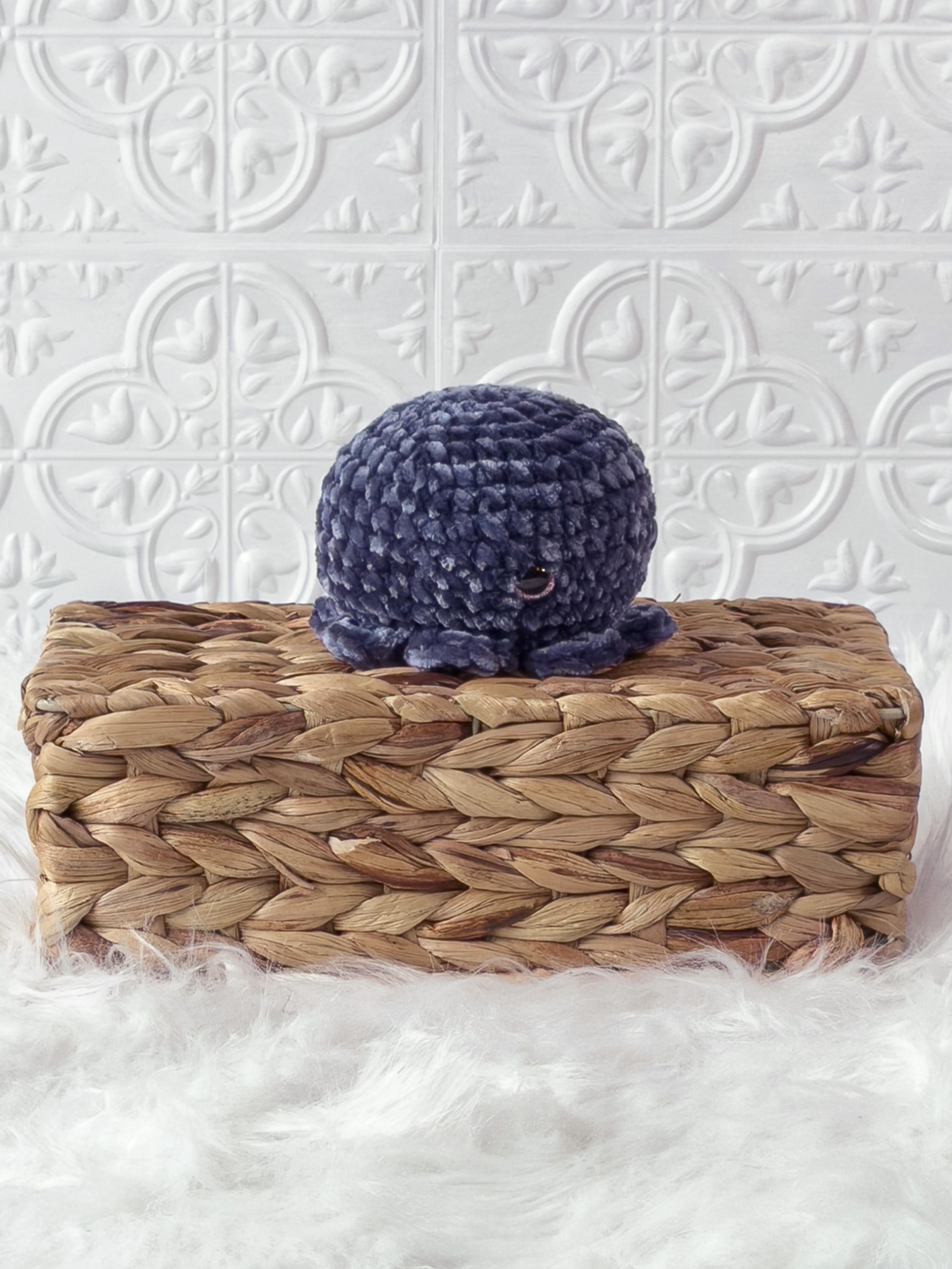 Handmade blue, dark octopus crochet plushie shown from an angled view