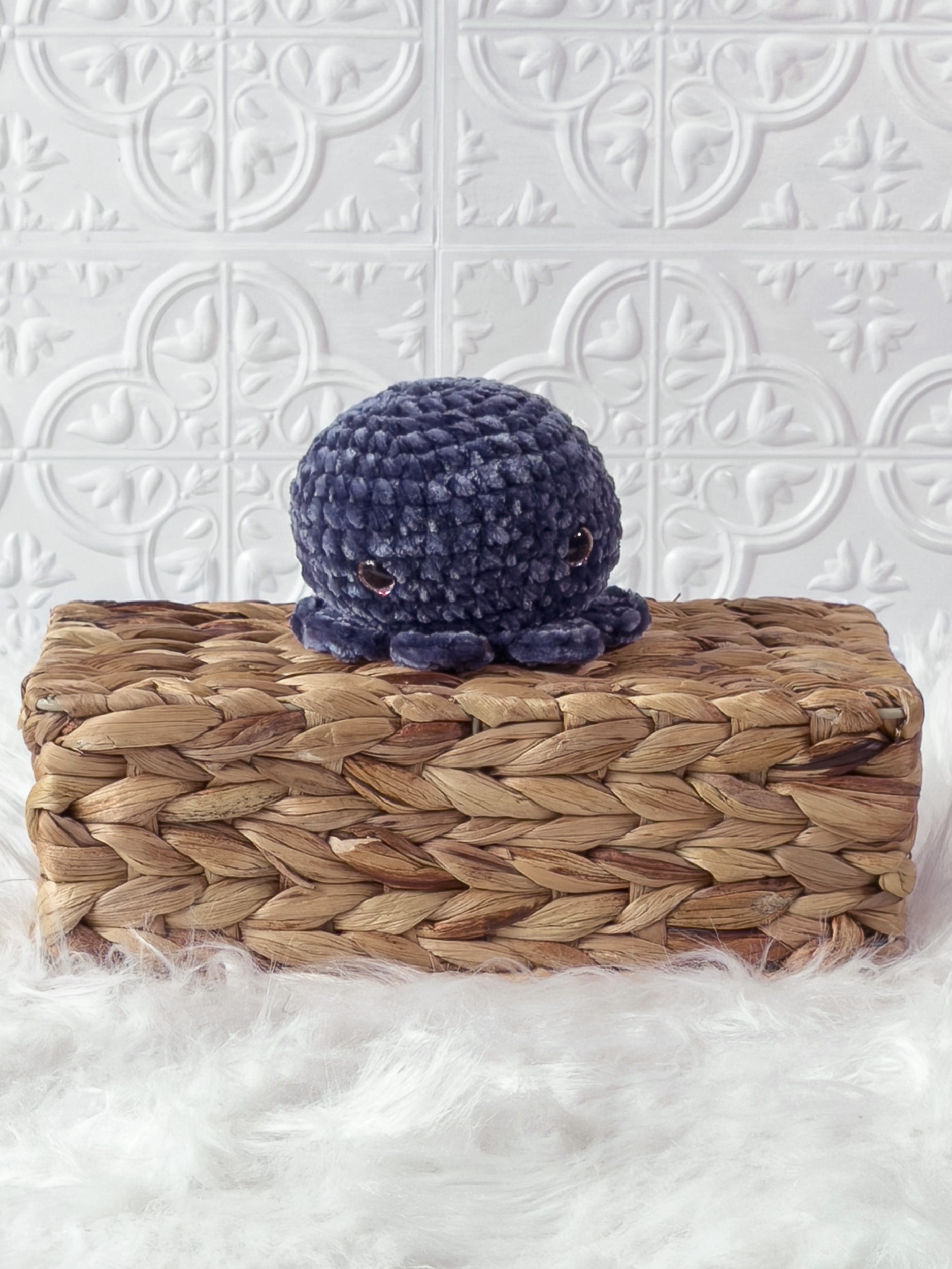 Handmade blue, dark octopus crochet plushie shown from the front