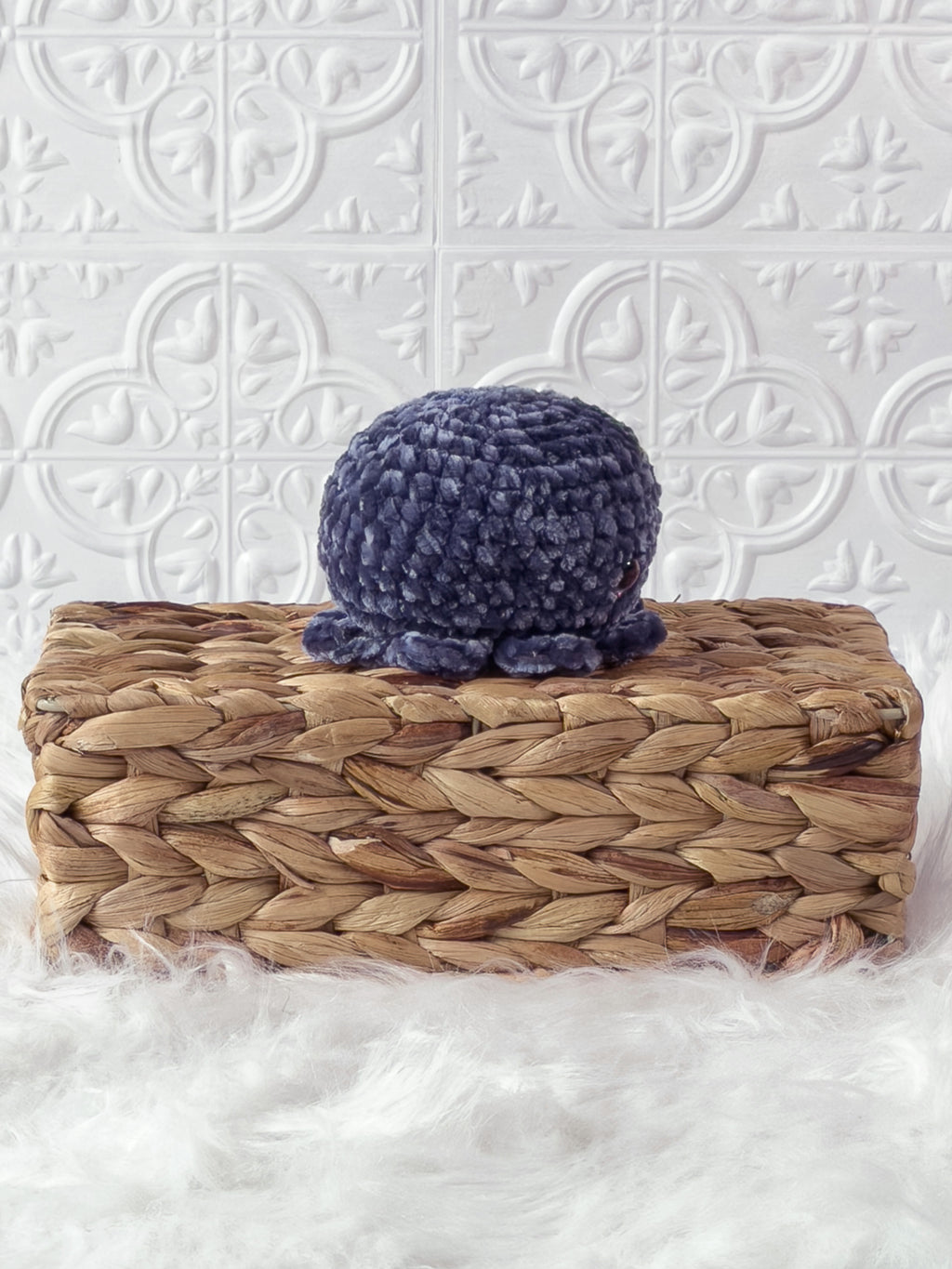 Handmade blue, dark octopus crochet plushie shown from the side