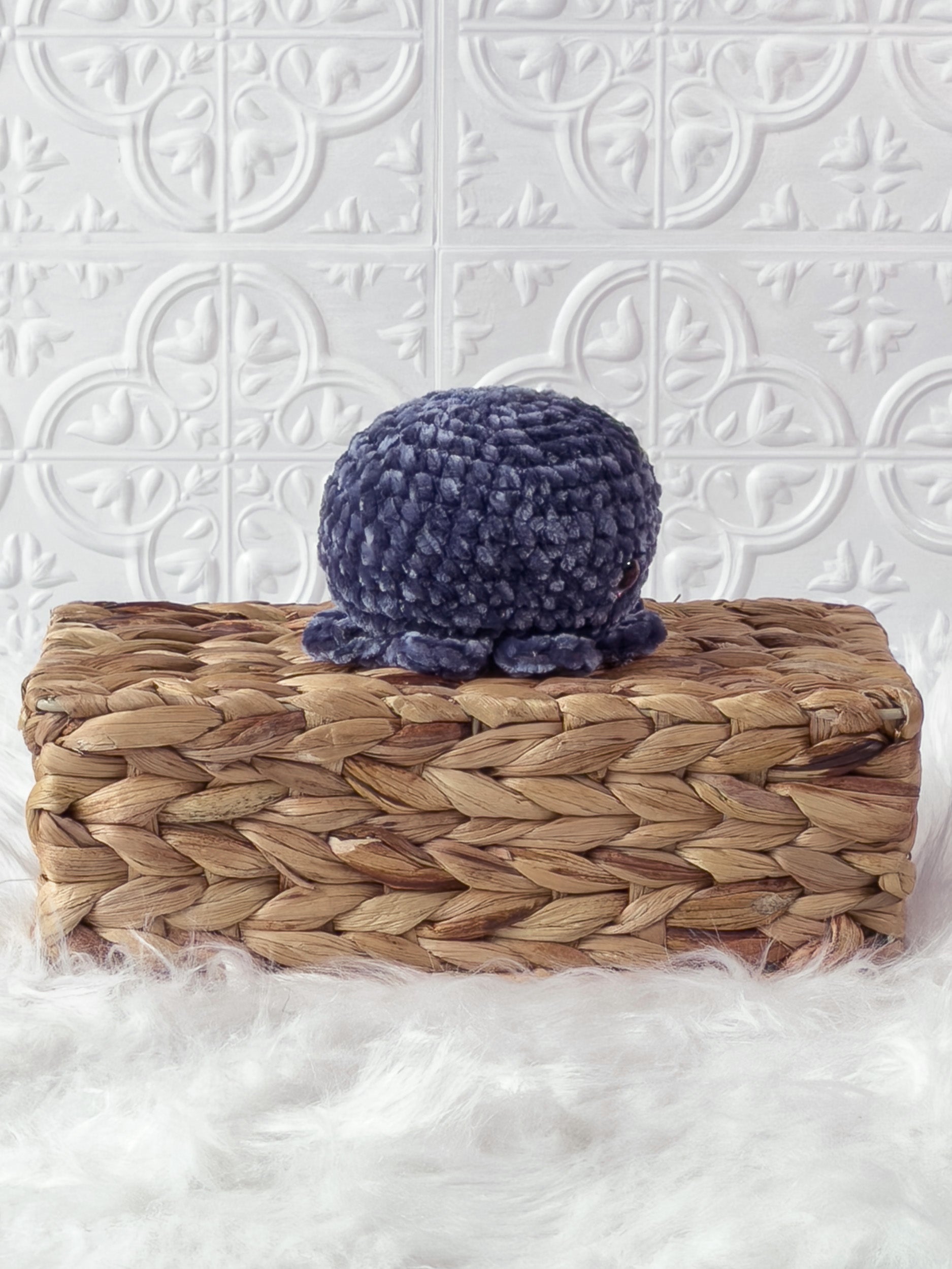 Handmade blue, dark octopus crochet plushie shown from the side