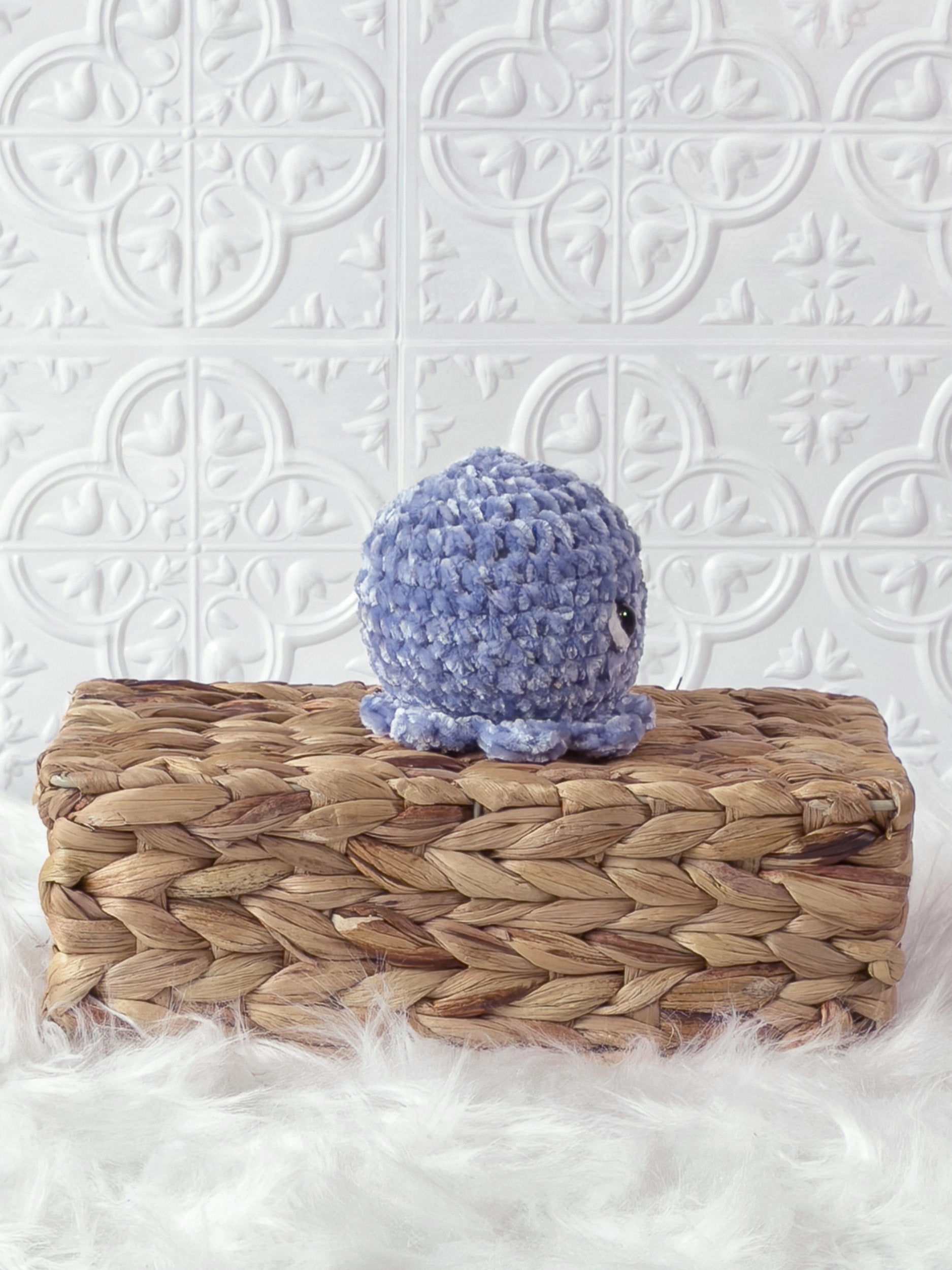 Handmade blue, light octopus crochet plushie shown from the side