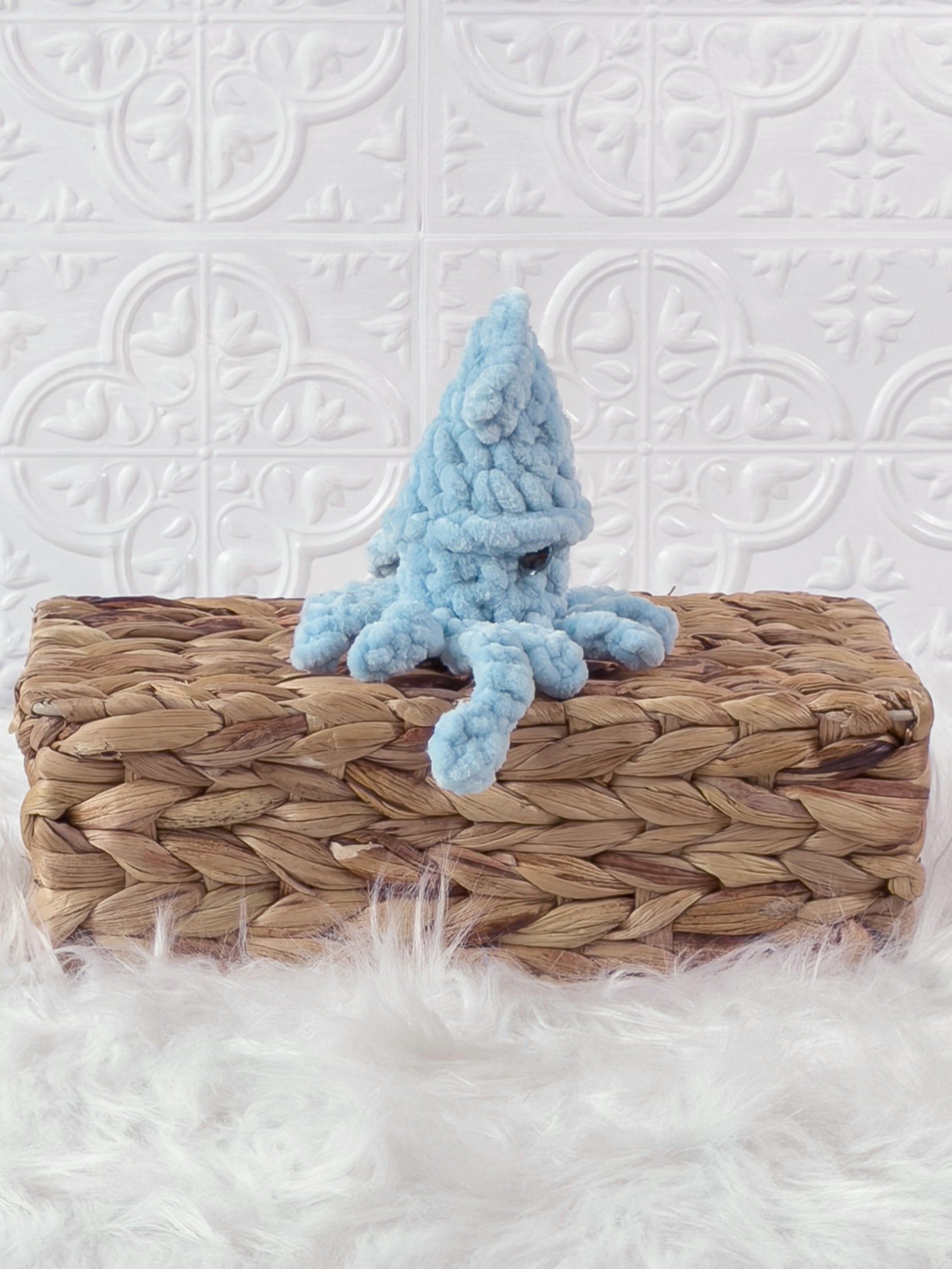 Handmade blue, light squid crochet plushie shown from the side