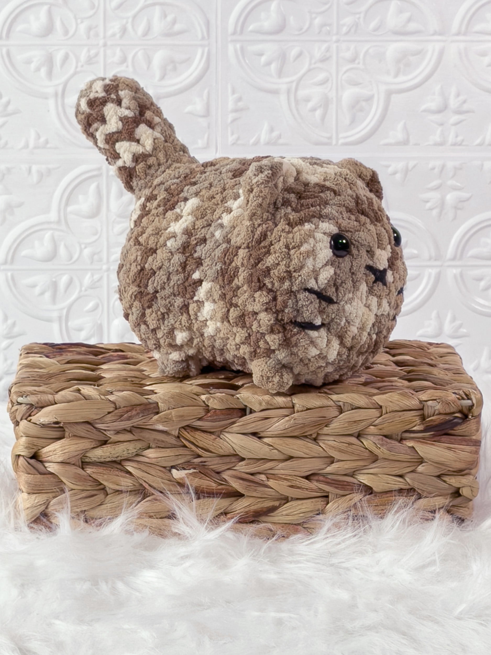 Handmade brown, dark big loaf cat crochet plushie shown from an angled view