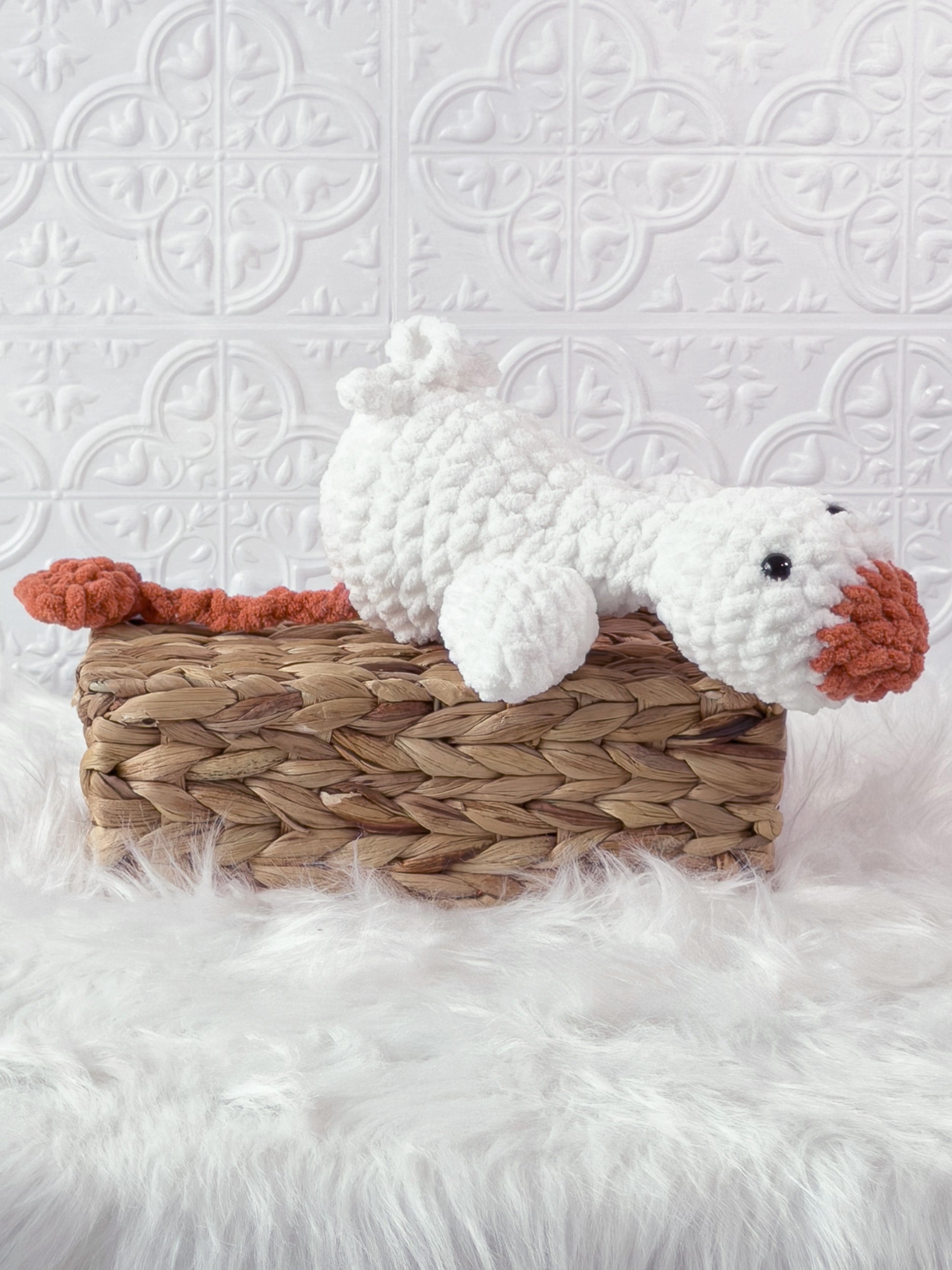 Handmade cream, orange silly goose crochet plushie shown from an angled view