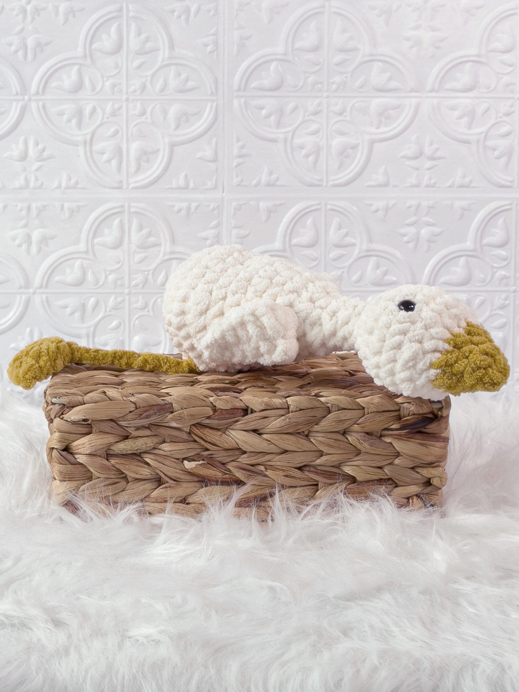 Handmade cream, yellow silly goose crochet plushie shown from an angled view