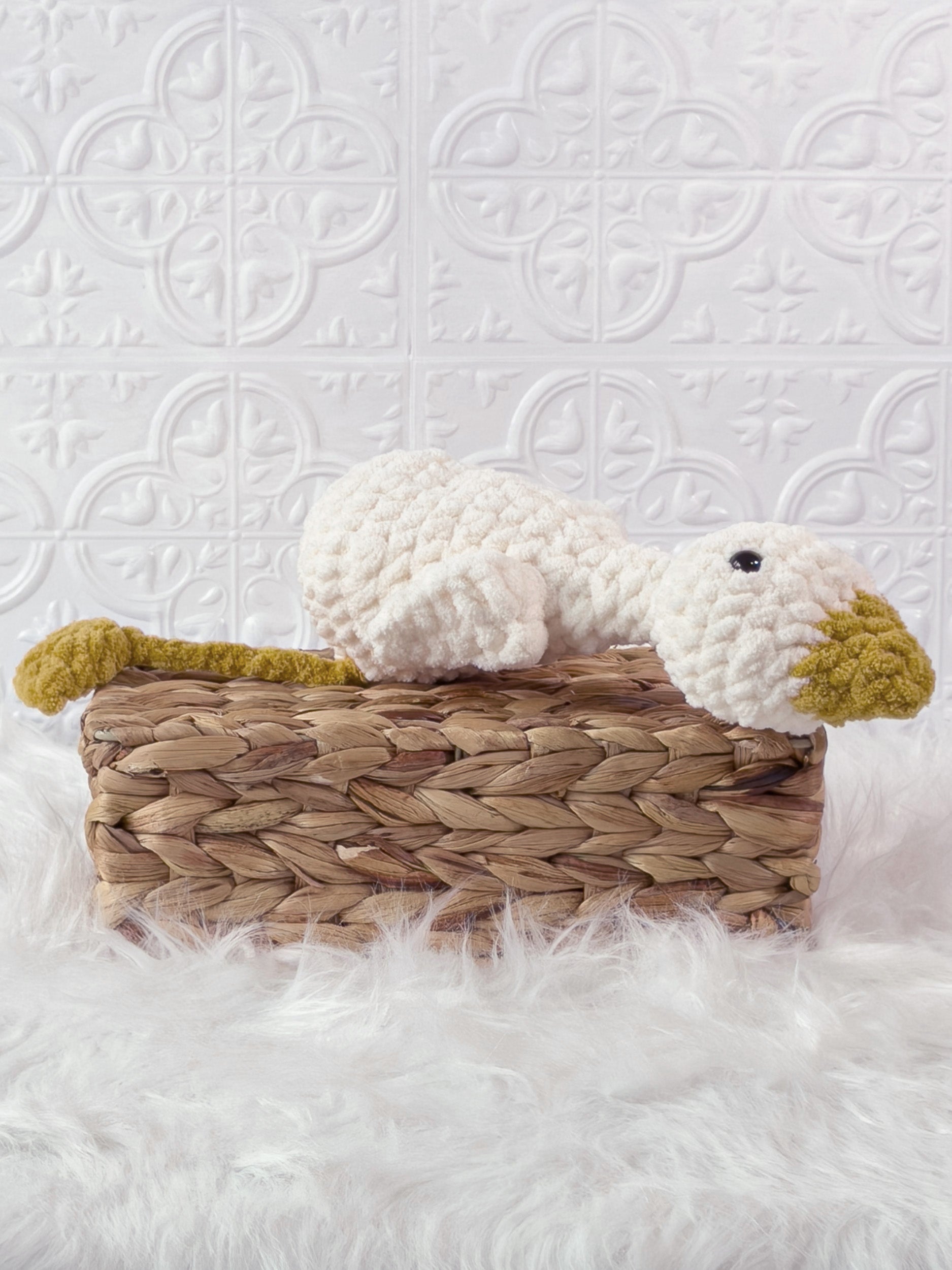 Handmade cream, yellow silly goose crochet plushie shown from an angled view