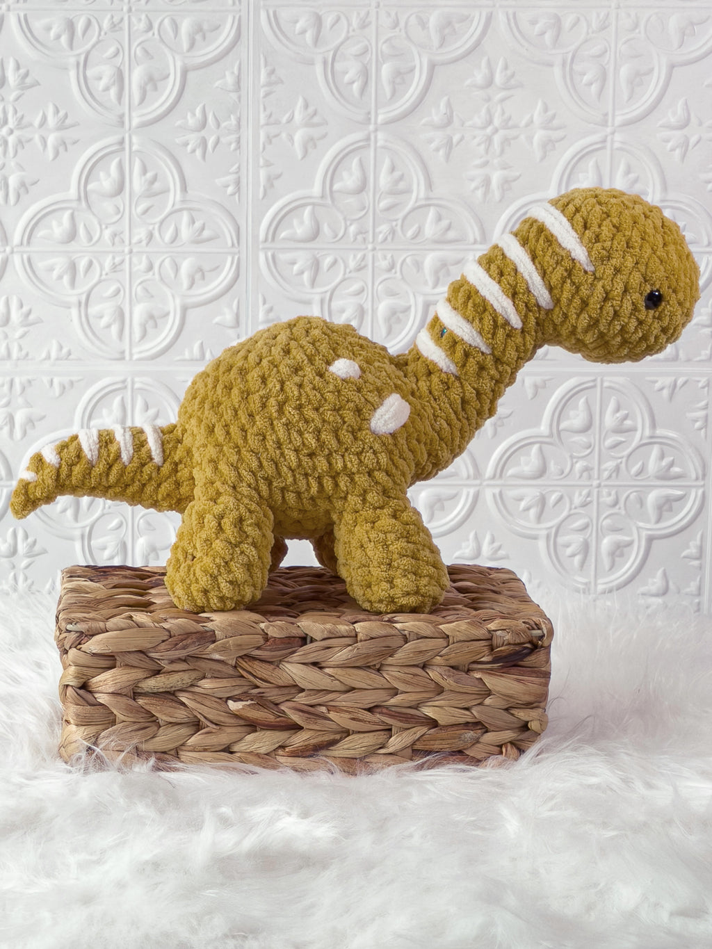 Handmade gold brachiosaurus crochet plushie shown from the side