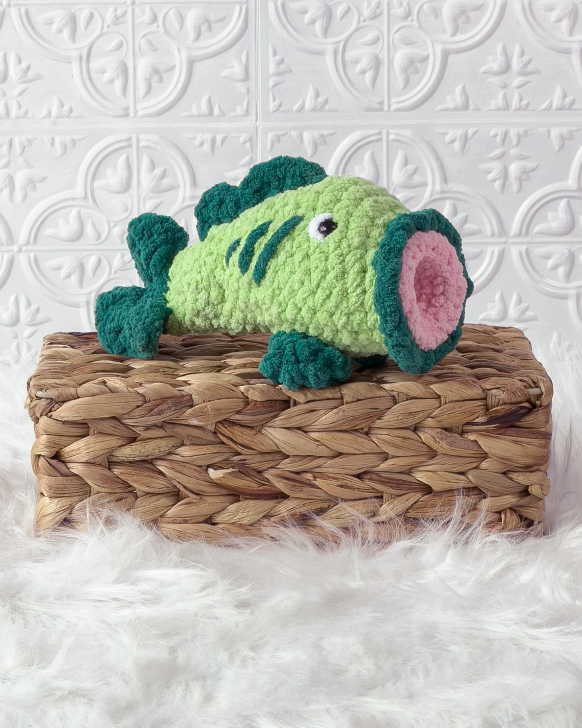 Handmade green bass fish crochet plushie shown from an angled view