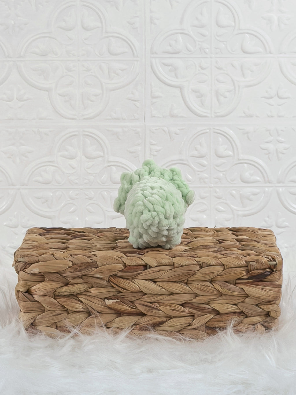 Handmade green triceratops crochet plushie shown from the back