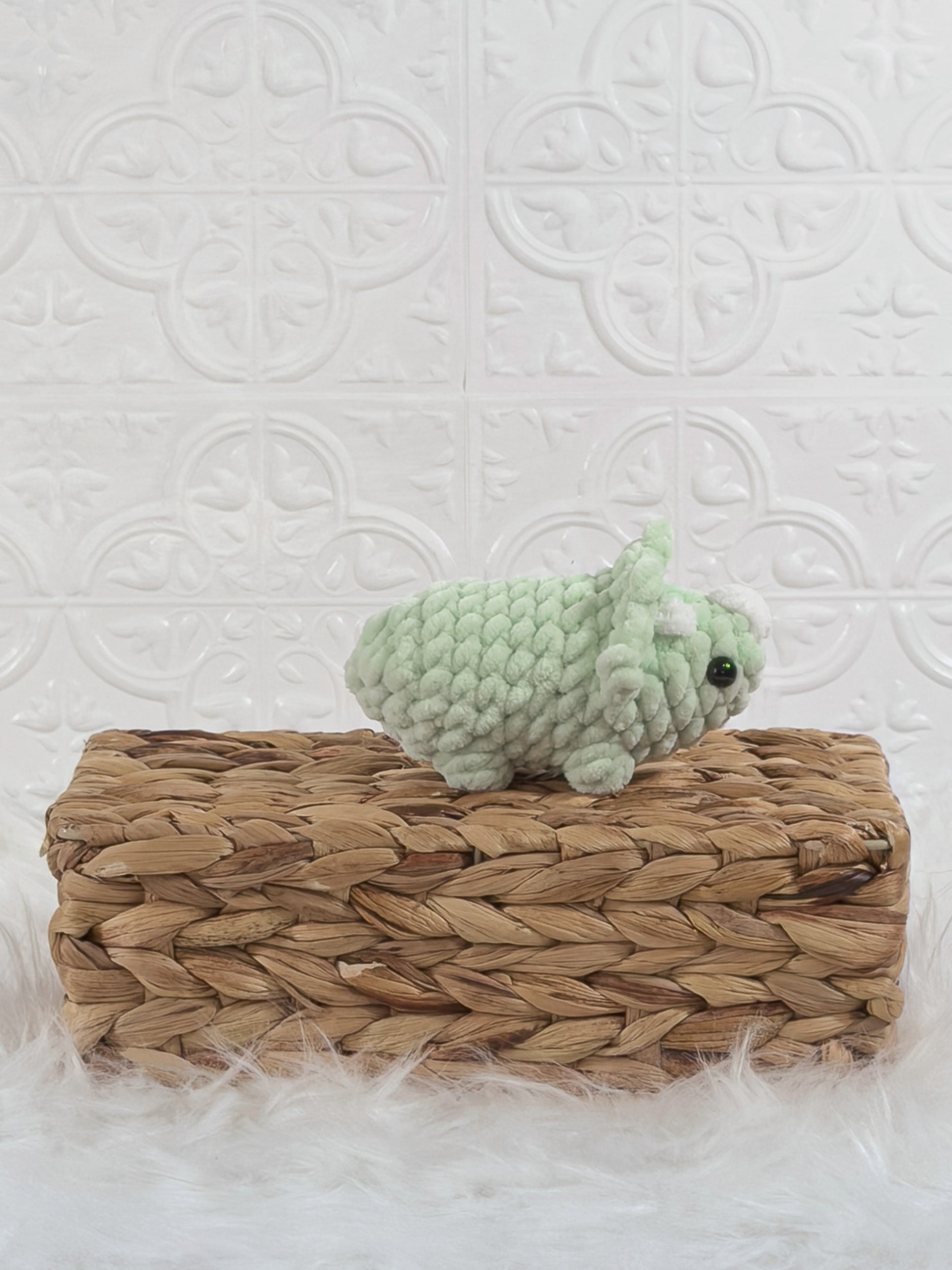 Handmade green triceratops crochet plushie shown from the side