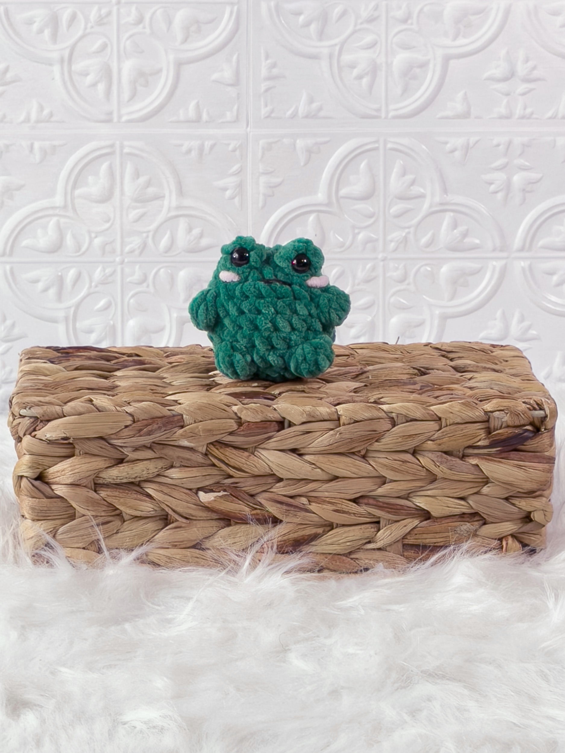 Handmade green, dark mini frog crochet plushie shown from the front