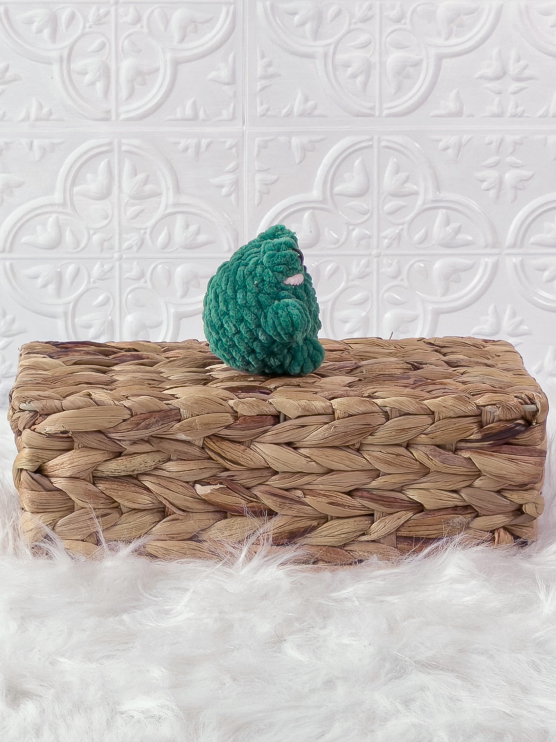Handmade green, dark mini frog crochet plushie shown from the side