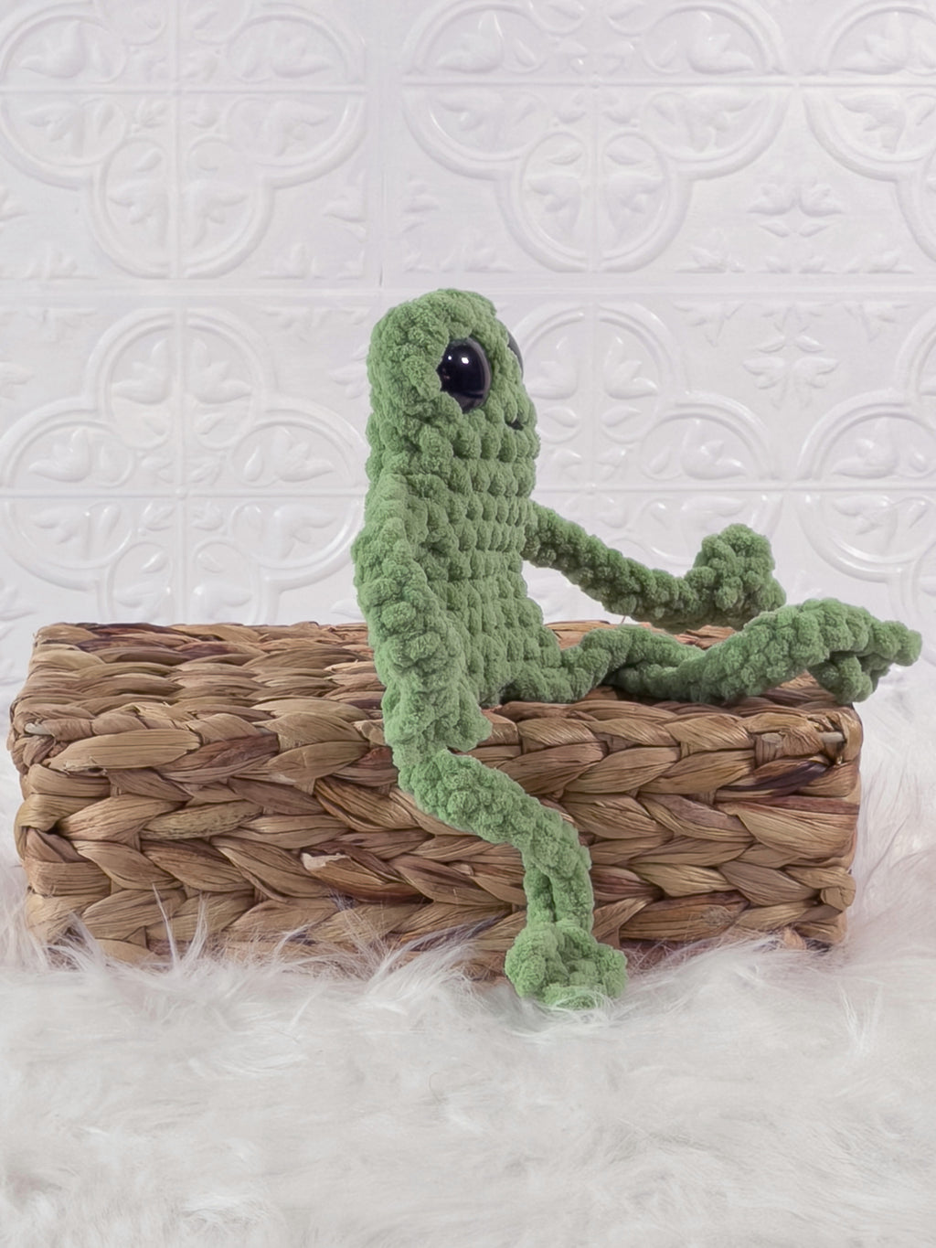 Handmade green, light leggy froggy crochet plushie shown from an angled view