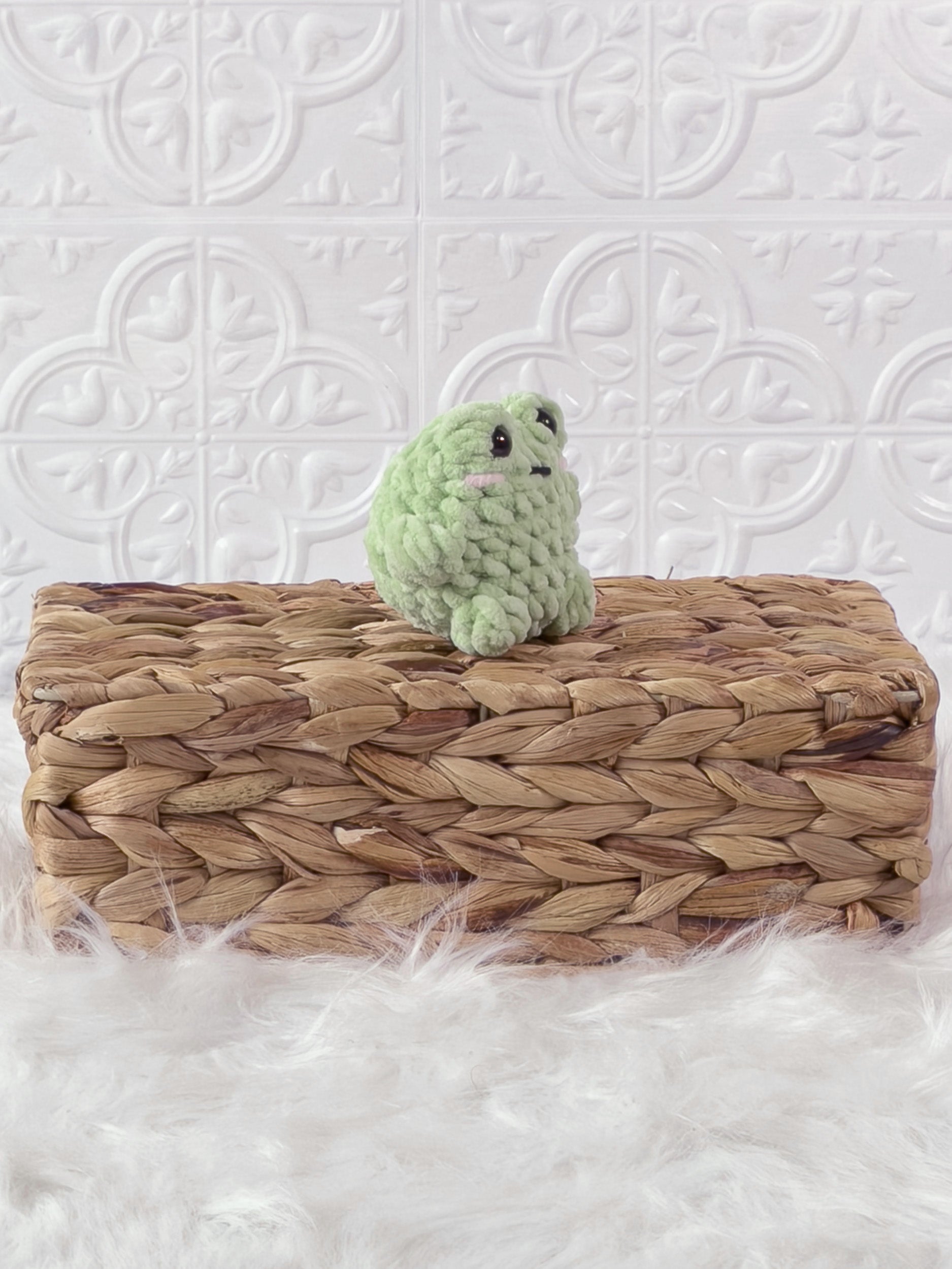 Handmade green, light mini frog crochet plushie shown from an angled view