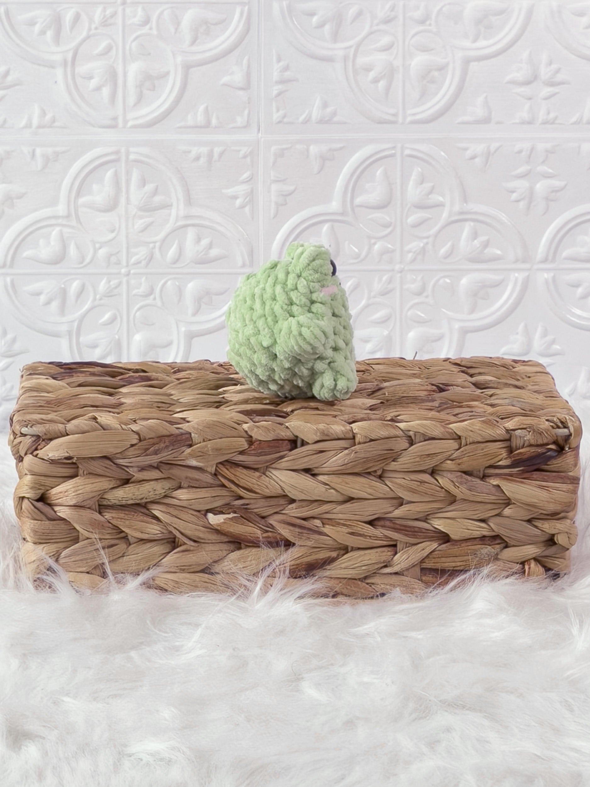 Handmade green, light mini frog crochet plushie shown from the side