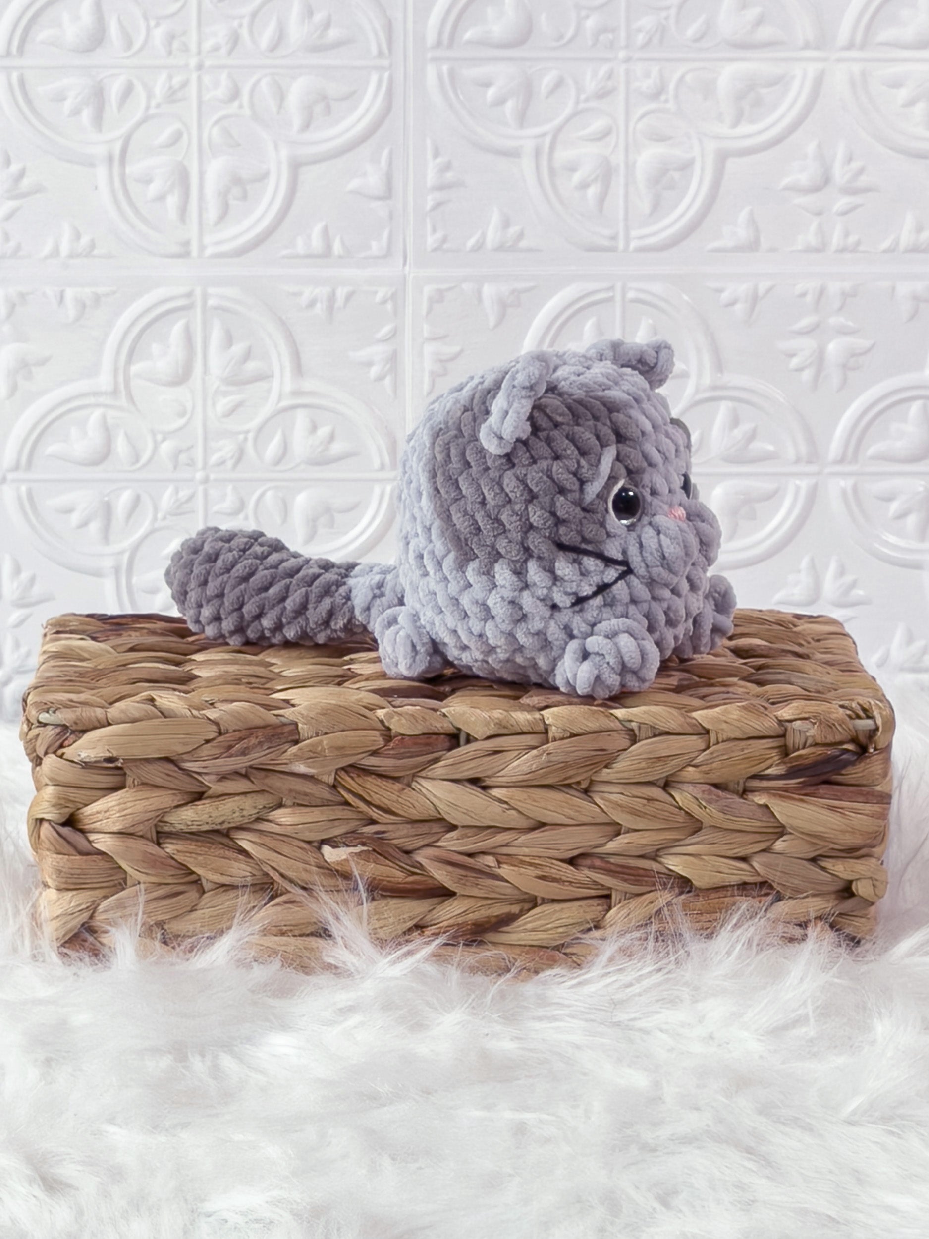 Handmade grey kitten crochet plushie shown from an angled view