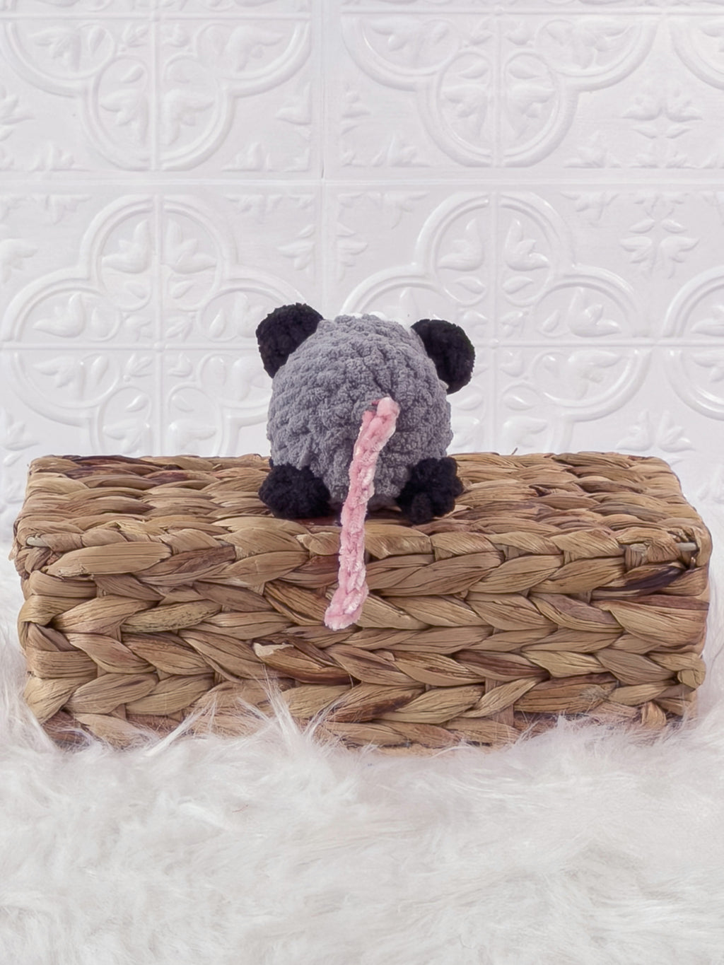 Handmade grey opossum crochet plushie shown from the back