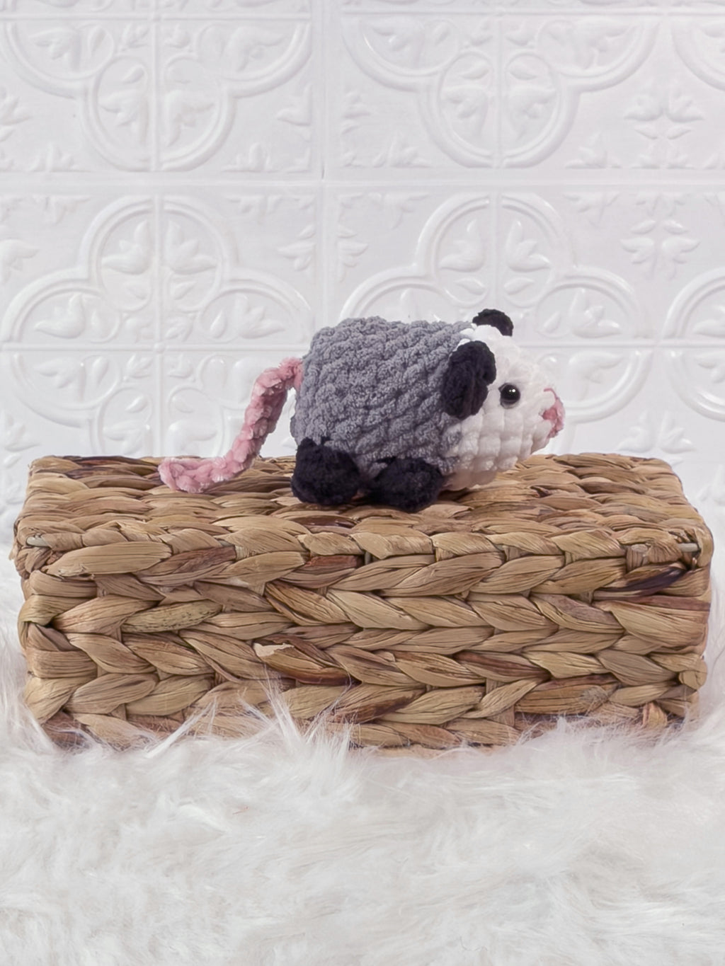 Handmade grey opossum crochet plushie shown from the side