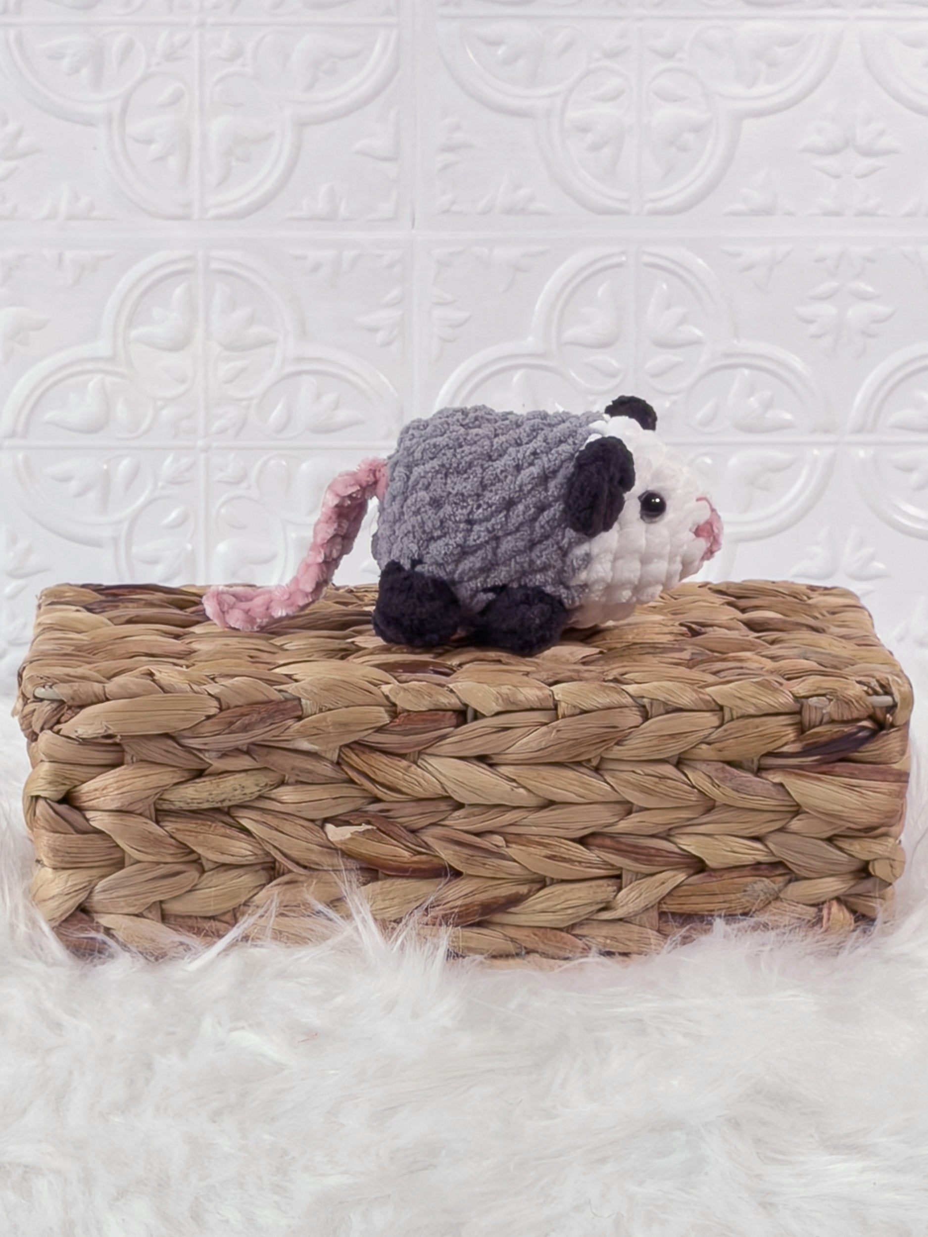 Handmade grey opossum crochet plushie shown from the side