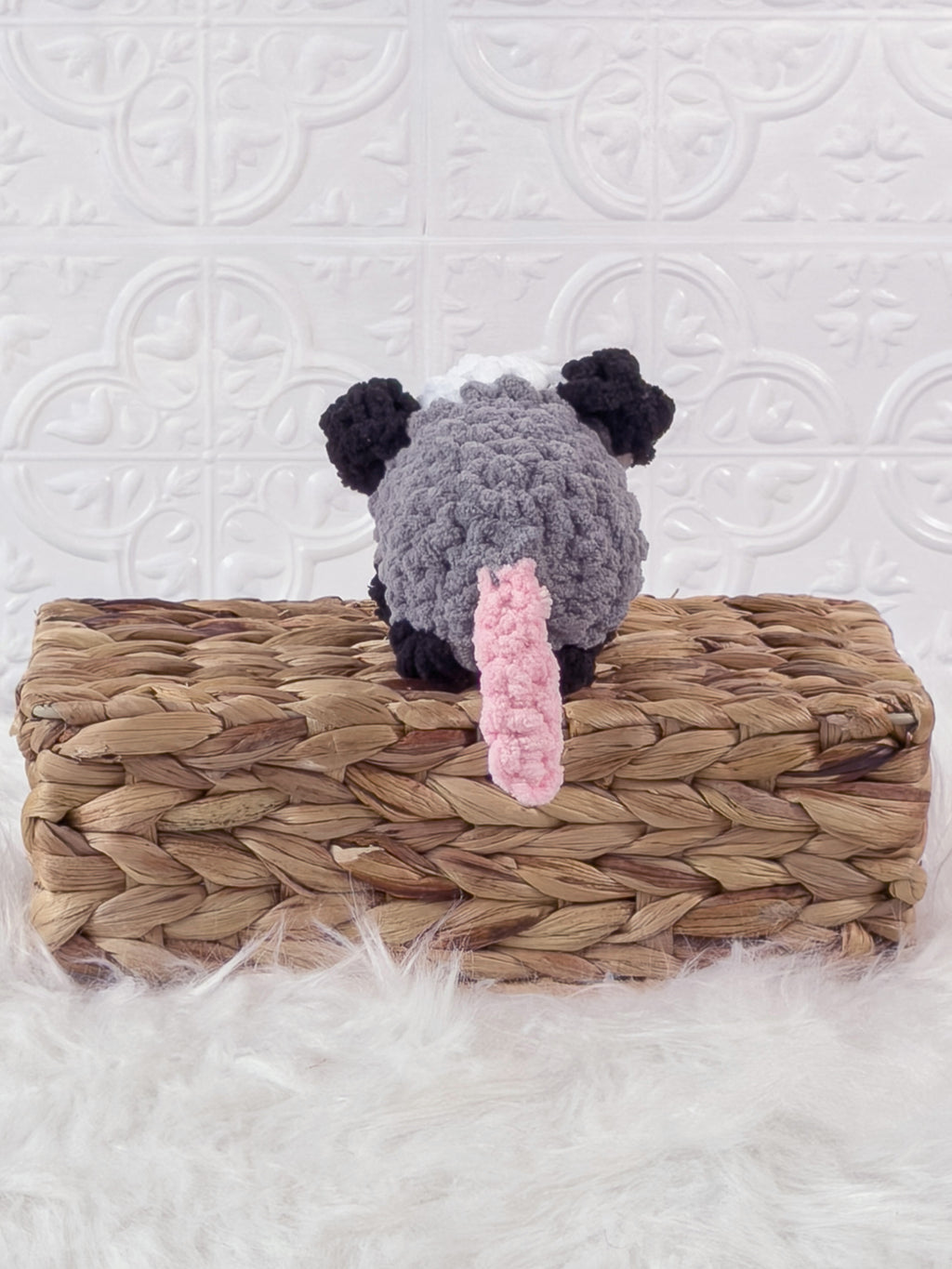 Handmade grey opossum crochet plushie shown from the back