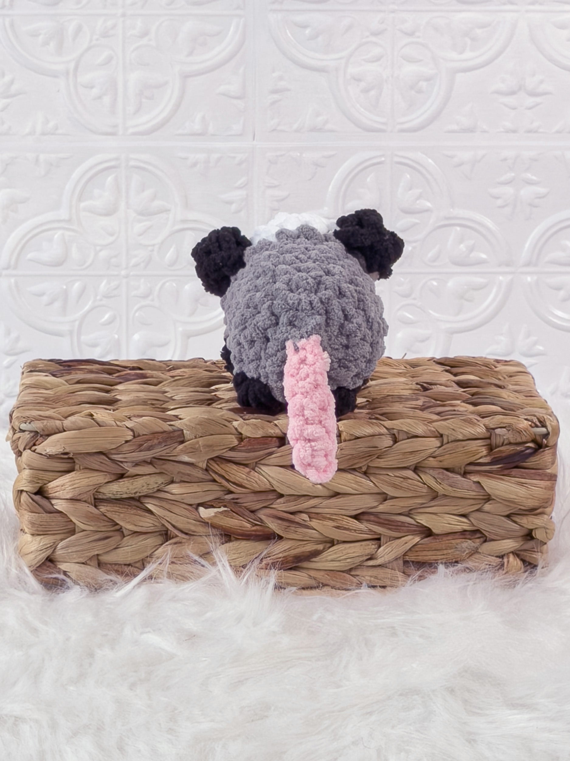 Handmade grey opossum crochet plushie shown from the back