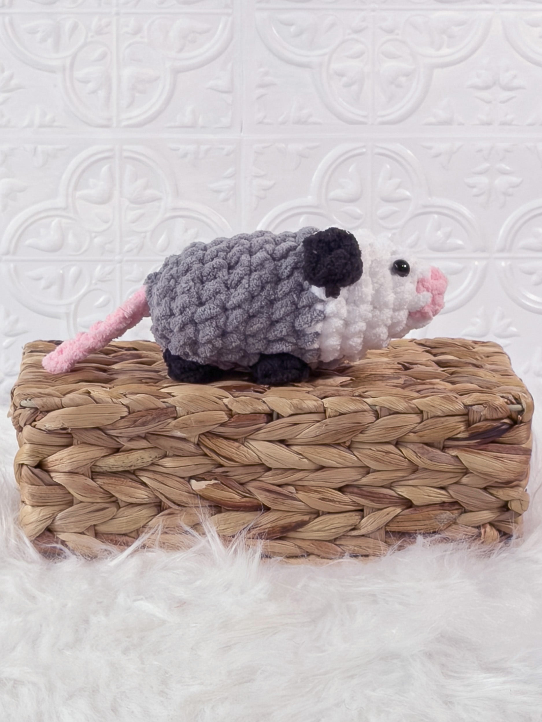 Handmade grey opossum crochet plushie shown from the side