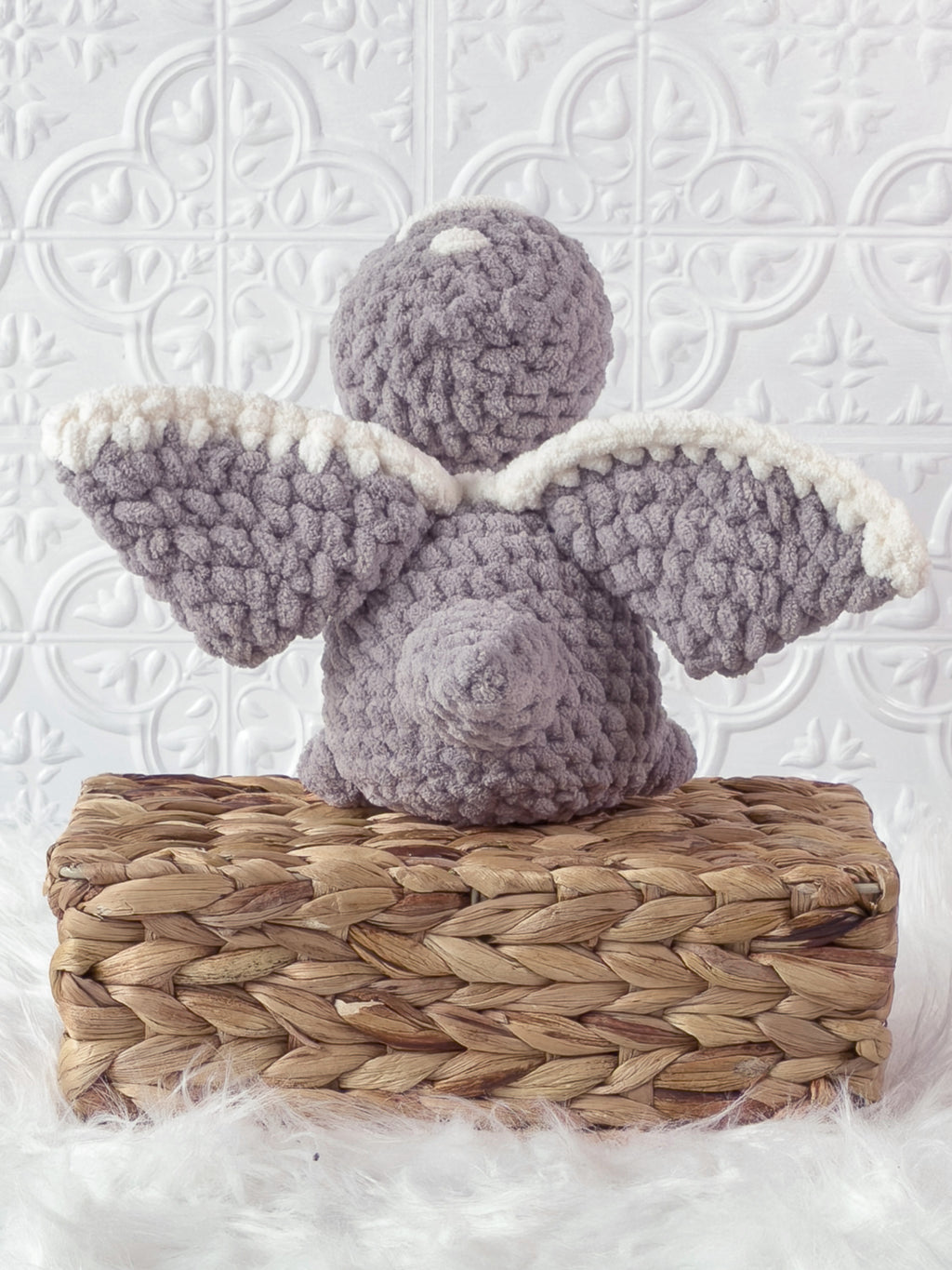 Handmade grey pterodactyl crochet plushie shown from the side
