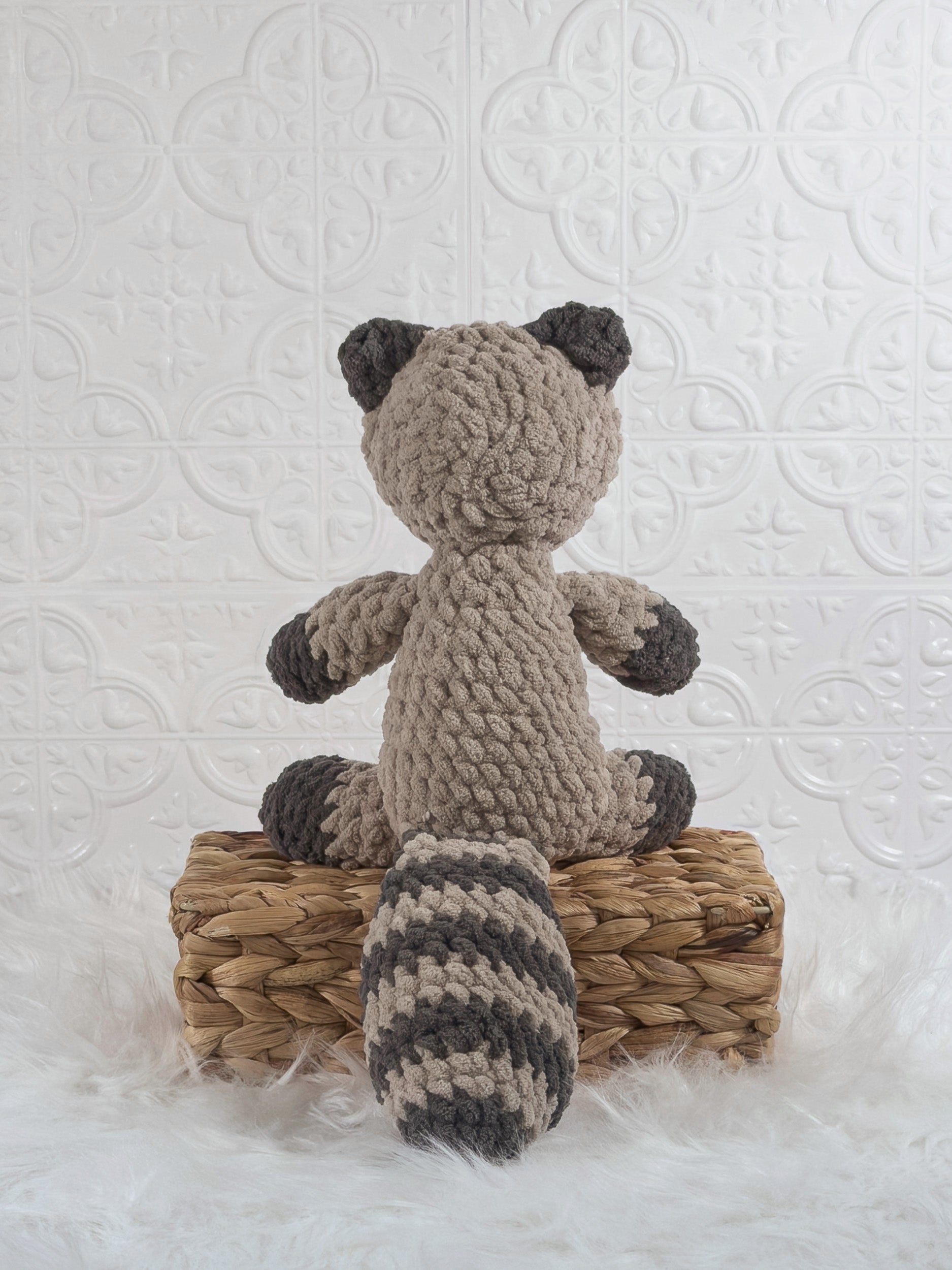 Handmade grey raccoon crochet plushie shown from the back