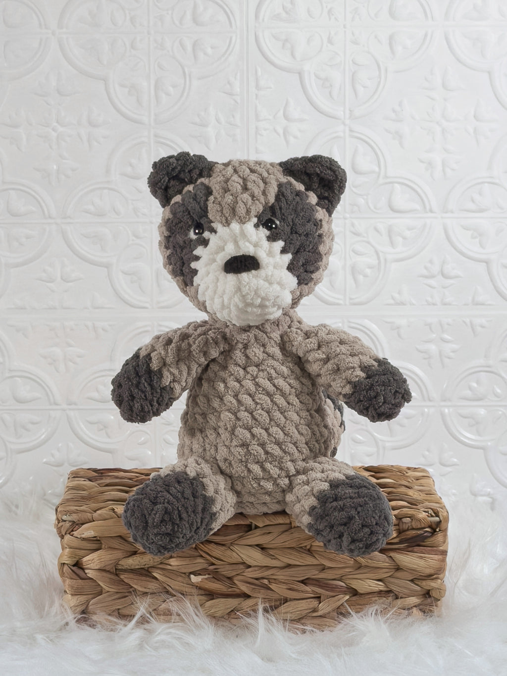 Handmade grey raccoon crochet plushie shown from the front